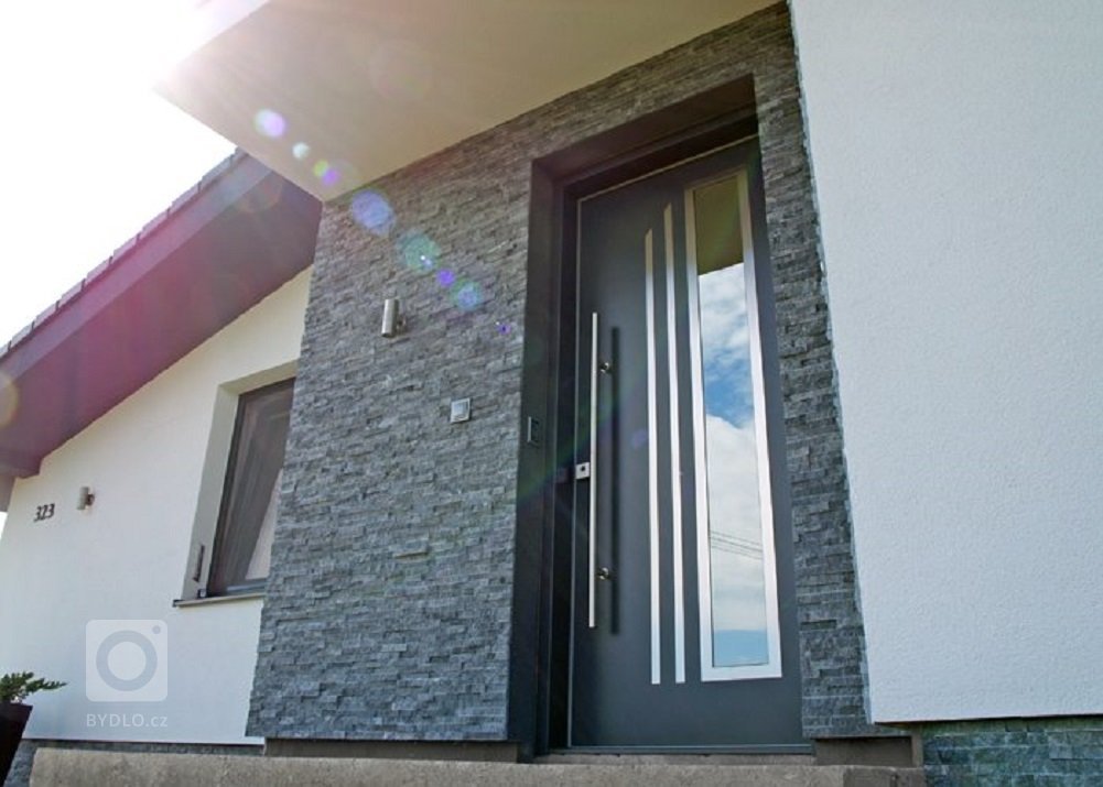 Moderní externí dveře s izolačními vlastmostmi dotváří vzhled přední části domu.
