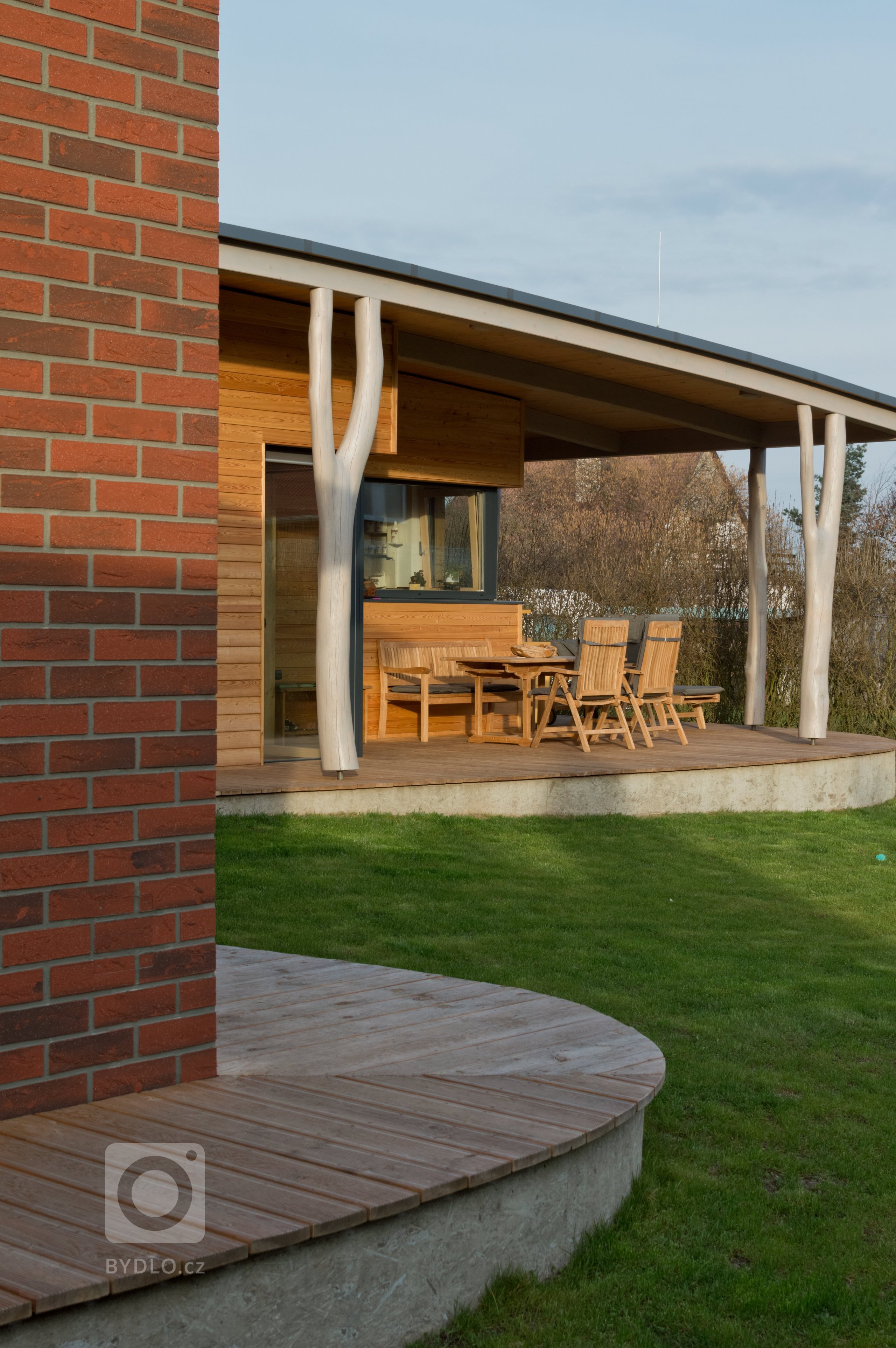 Jedná se o jednoduchý přízemní dům o půdorysném tvaru &bdquo;L&quot;. Obě ramena domu se otevírají směrem do zahrady. Z kratšího ramene vystupuje kuchyně,…