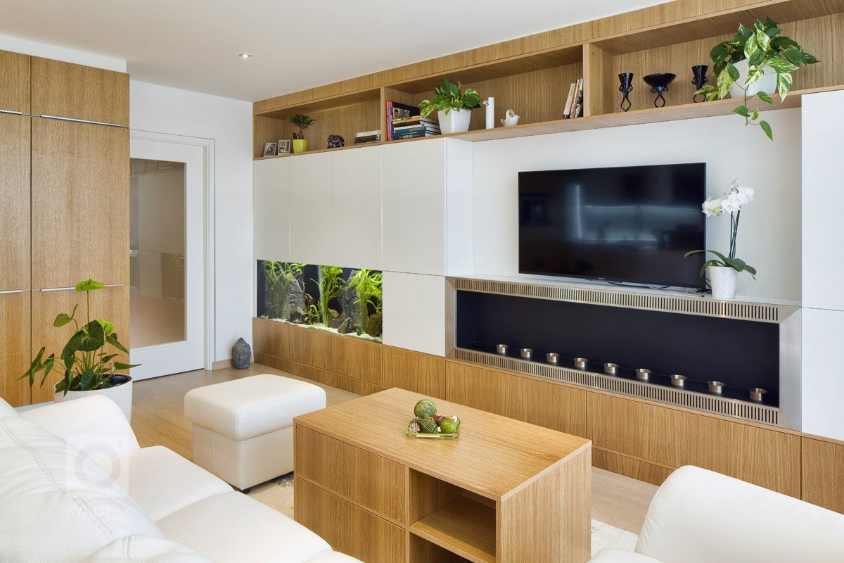 Rekonstrukce panelového bytu v odstínech dřeva a bílé.
