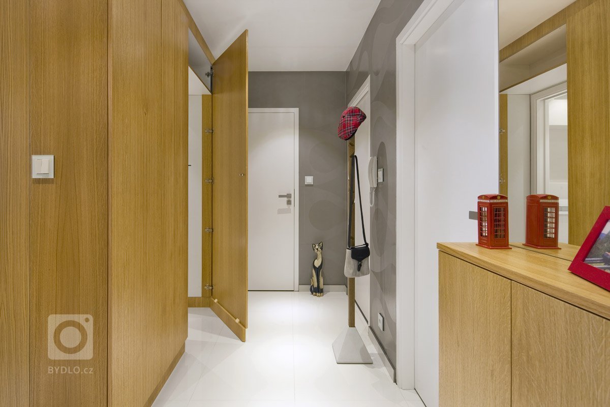 Rekonstrukce panelového bytu v odstínech dřeva a bílé.
