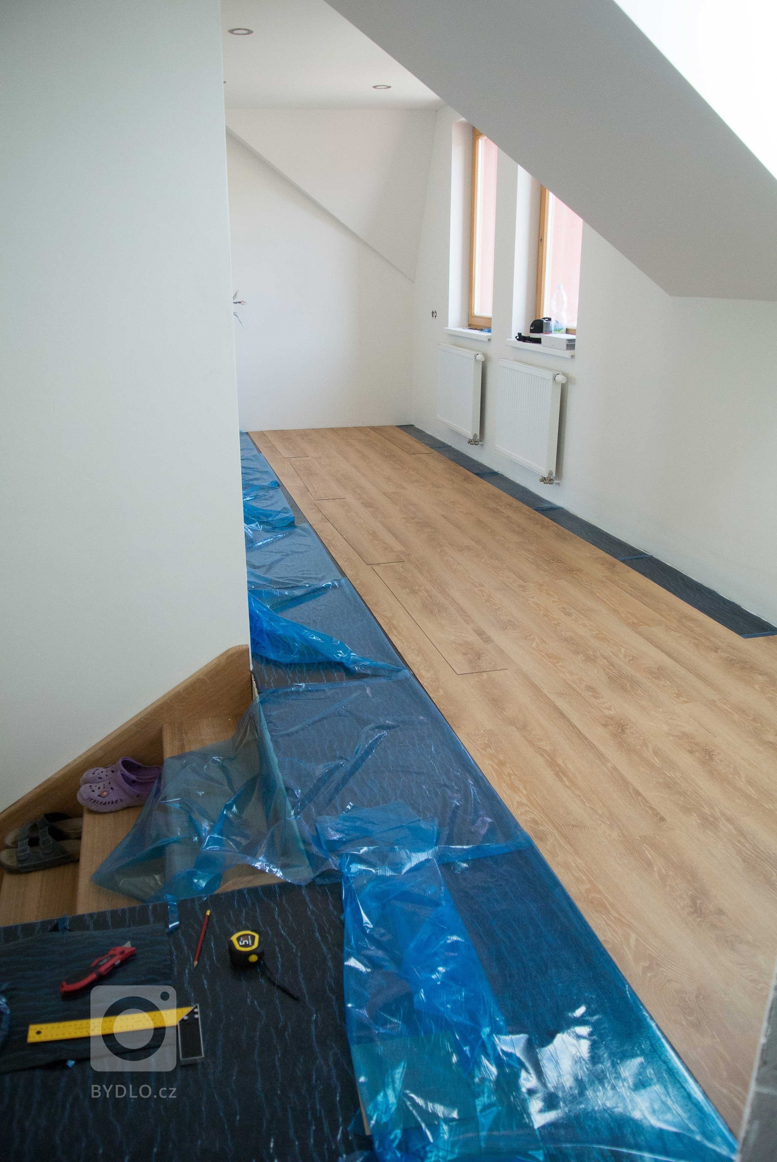 Následně se ze samolepicí vrstvy odstraňuje fólie a pokládá se vinylová podlaha