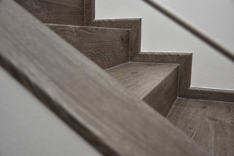 Schody z vinylové podlahy, detial řešení soklových lišt na schodech