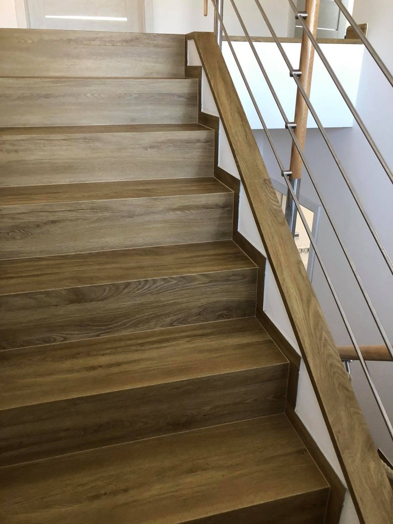 Schodiště s vinylovou podlahou BUKOMA PREMIUM CLICK Dub Gladstone Hnědý. Stejný dekor jako na podlaze je i na téměř všech plochách v domě, položeno bez…