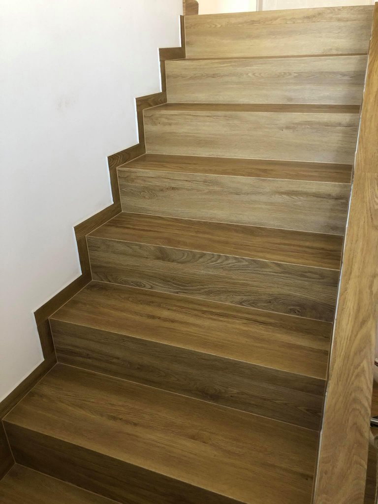 Schodiště s vinylovou podlahou BUKOMA PREMIUM CLICK Dub Gladstone Hnědý. Stejný dekor jako na podlaze je i na téměř všech plochách v domě, položeno bez…