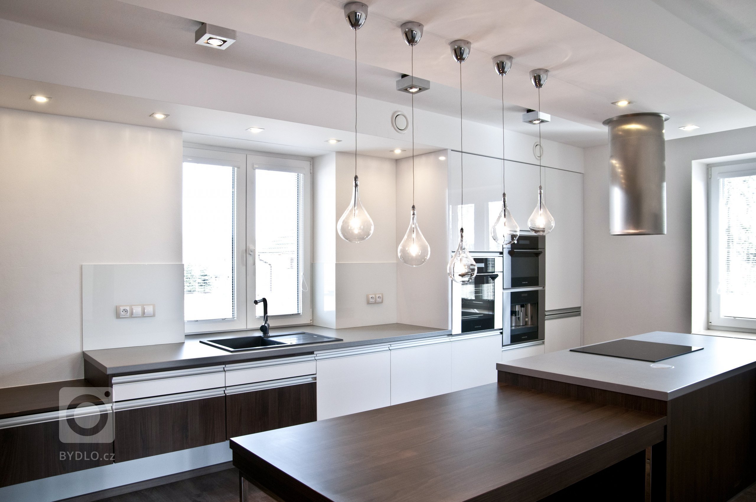 Velice moderní kuchyňská sestava působící luxusním dojmem. Majitelé vsadili na bílou lesklou barvu a velmi oblíbený dekor ořechu Ribera. Krásu kuchyně pak…