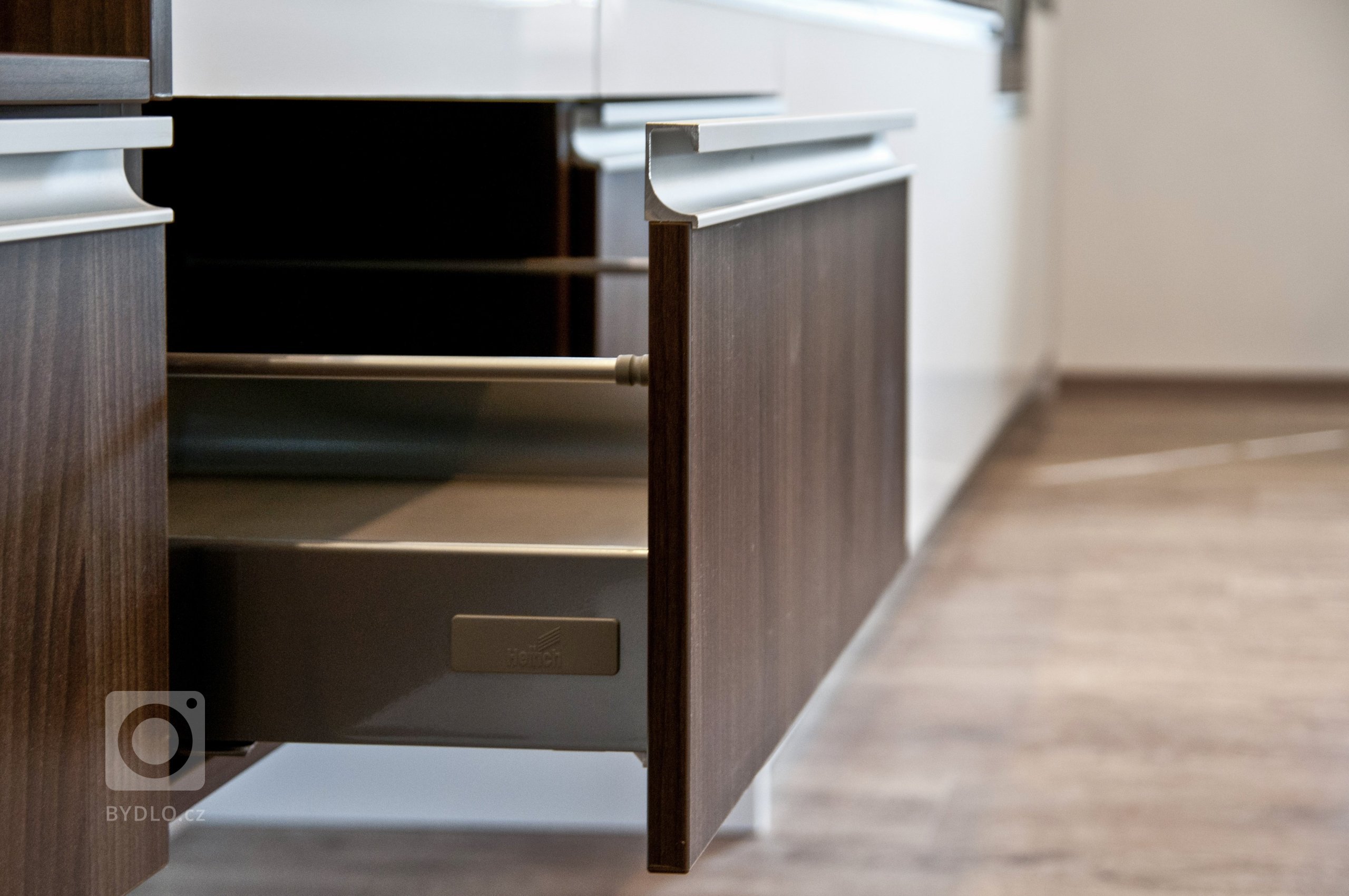 Velice moderní kuchyňská sestava působící luxusním dojmem. Majitelé vsadili na bílou lesklou barvu a velmi oblíbený dekor ořechu Ribera. Krásu kuchyně pak…