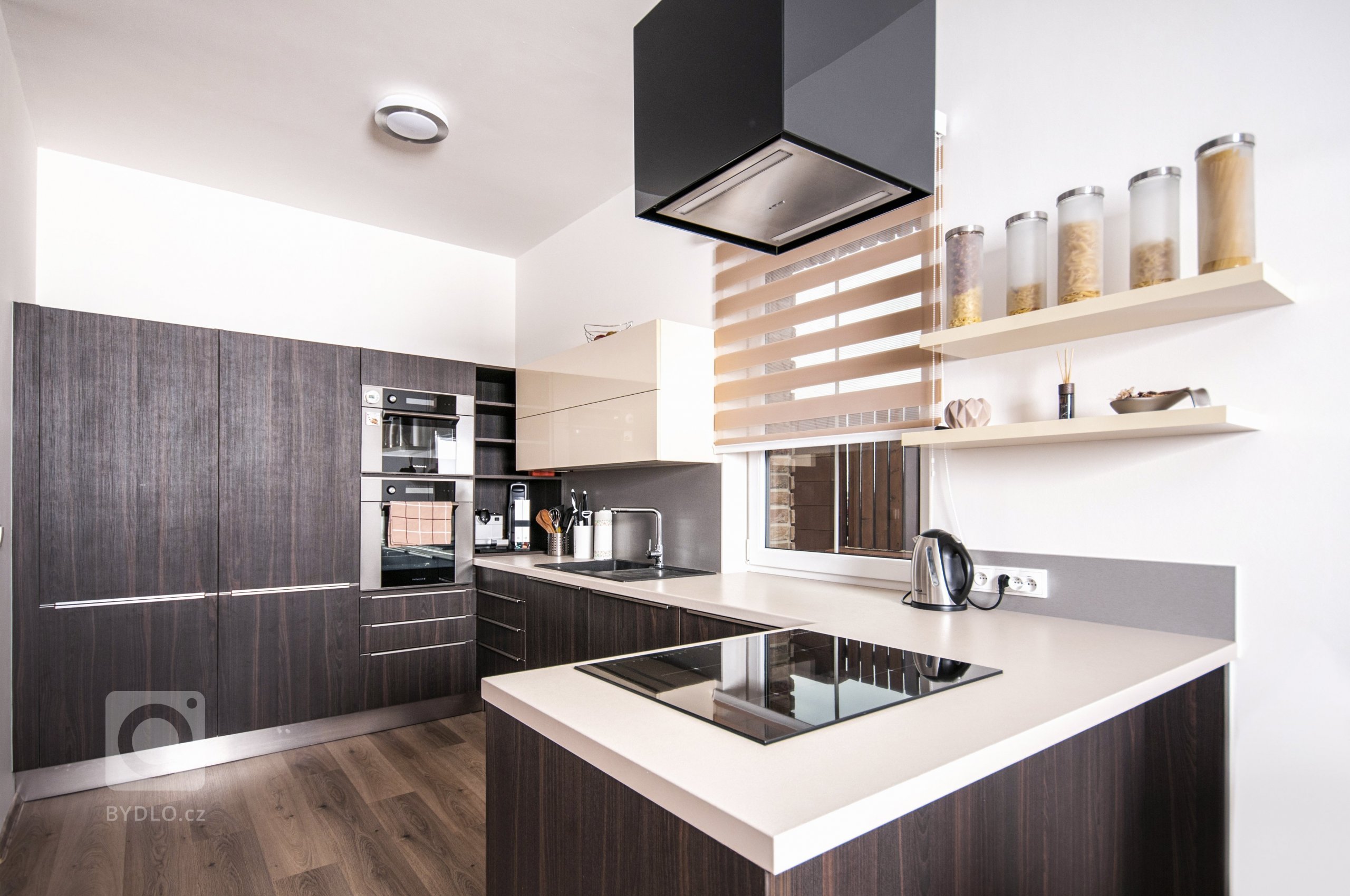 Elegantní, malá, ale přesto plně funkční kuchyň s vařením v prostoru, které udržuje kuchařku v kontaktu se zbytkem obývací místnosti. Sestava skříní skrývá…