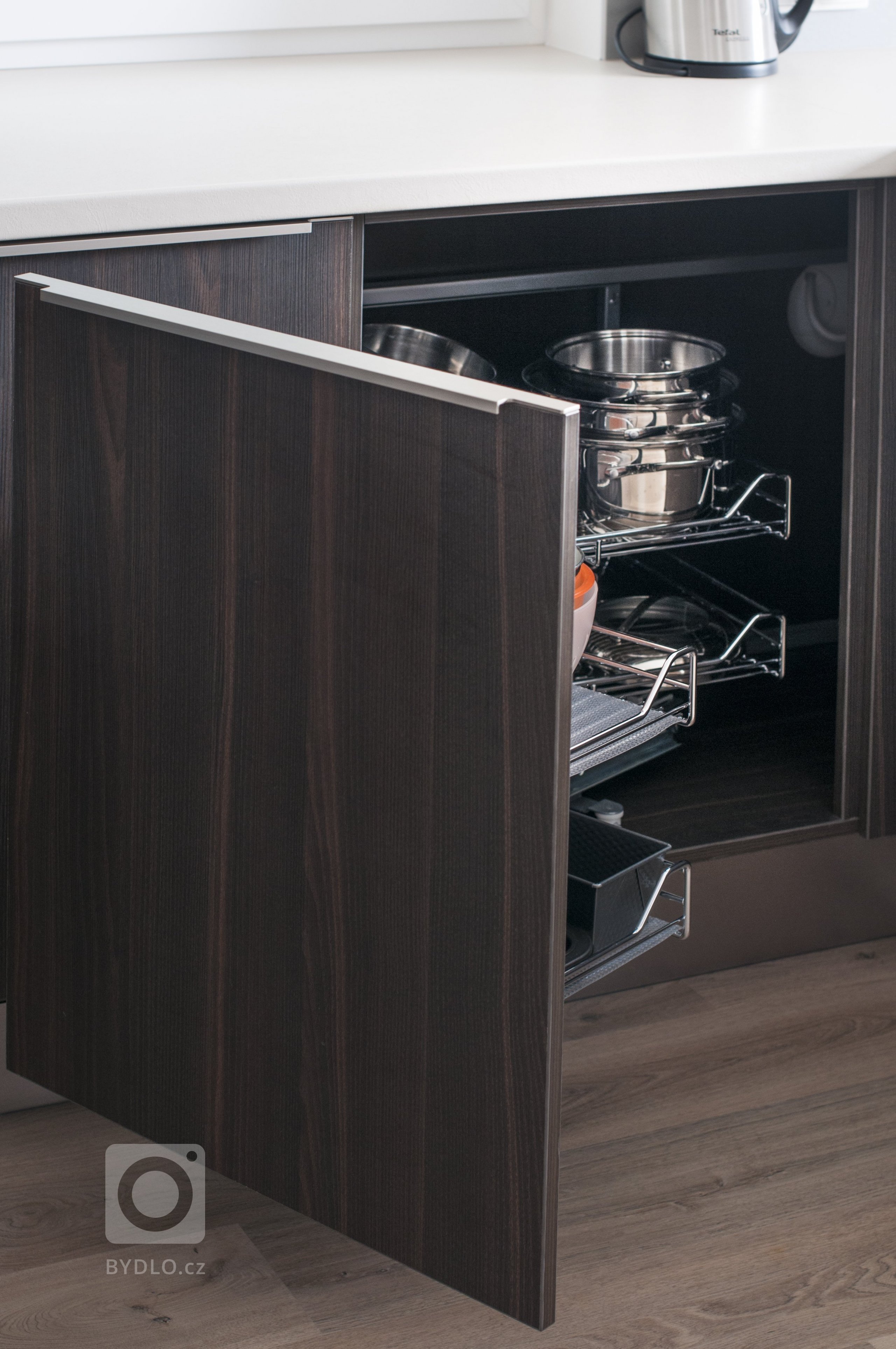 Elegantní, malá, ale přesto plně funkční kuchyň s vařením v prostoru, které udržuje kuchařku v kontaktu se zbytkem obývací místnosti. Sestava skříní skrývá…