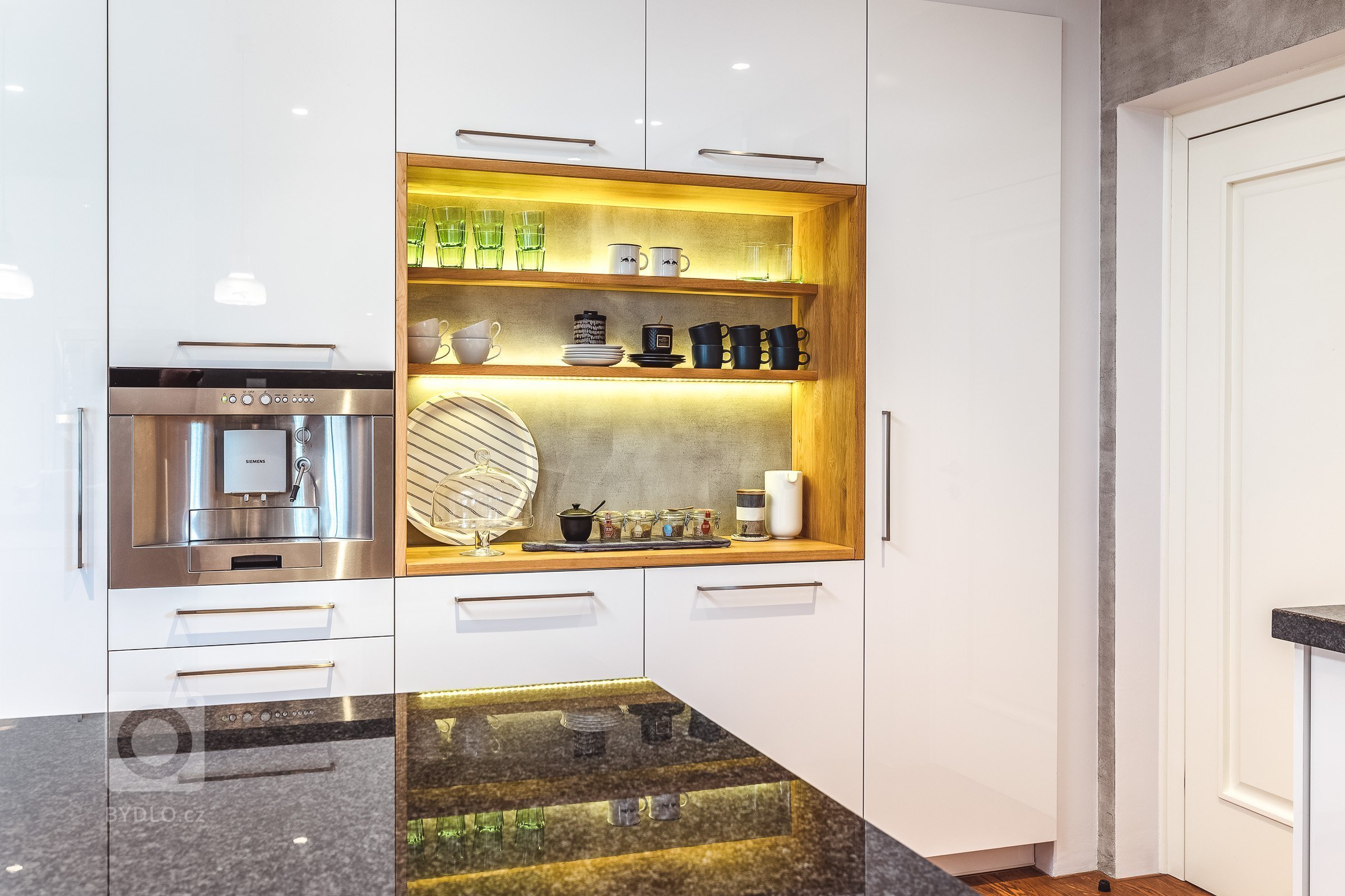 Pracovat na návrhu a realizaci tohoto prostoru mě velice těšilo. Vybraná kombinace betonové stěrky, bílé lakované MDF, černé kamenné pracovní desky a dřeva…