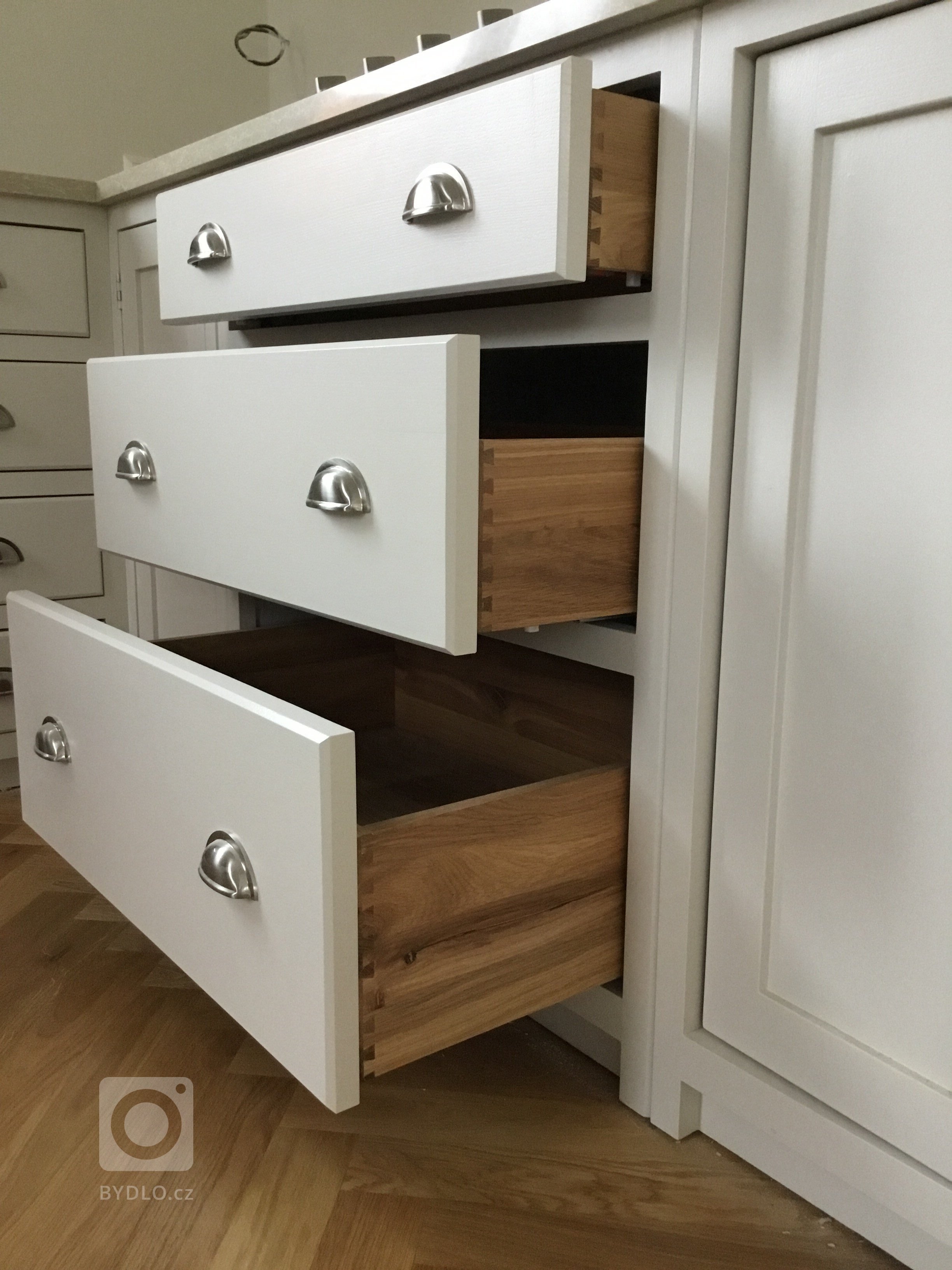 Šuplíky vyrobené z dubového dřeva, s rybinovým čepem a na BLUM soft close pojezdech. Úchyty dovezené z Anglie.