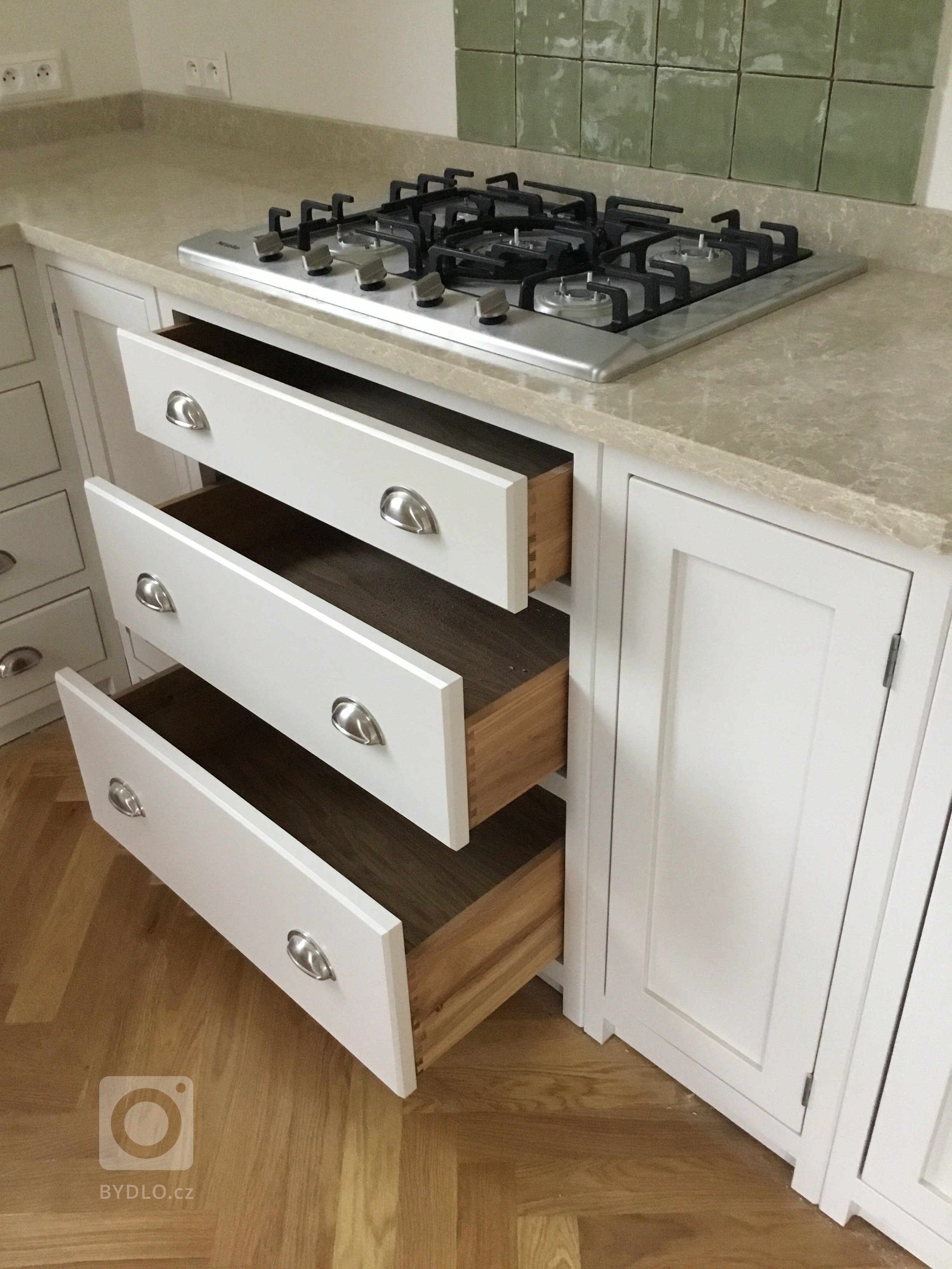 Šuplíky vyrobené z dubového dřeva, s rybinovým čepem a na BLUM soft close pojezdech.  Úchyty dovezené z Anglie.