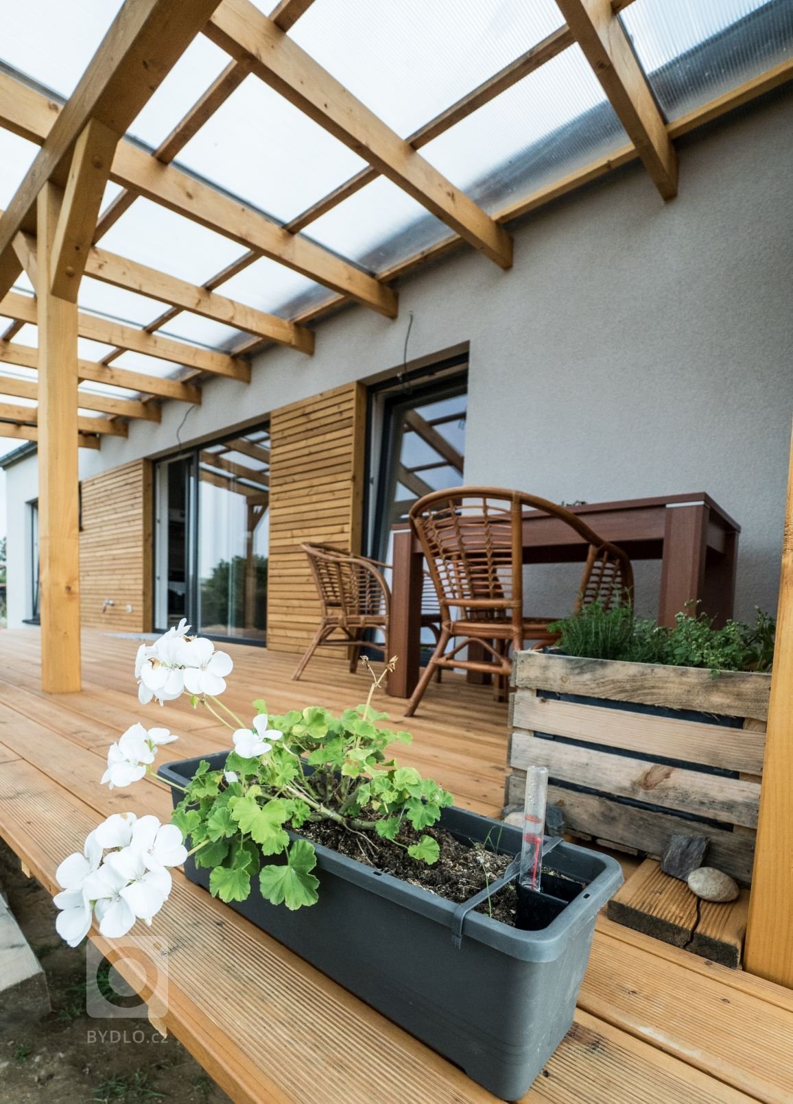 Dřevostavba EASY 48 s terasou a pergolou dokončená letos v létě. Kombinace bílé fasády, antracitové střechy a oken a obkladu ze sibiřského modřínu s…