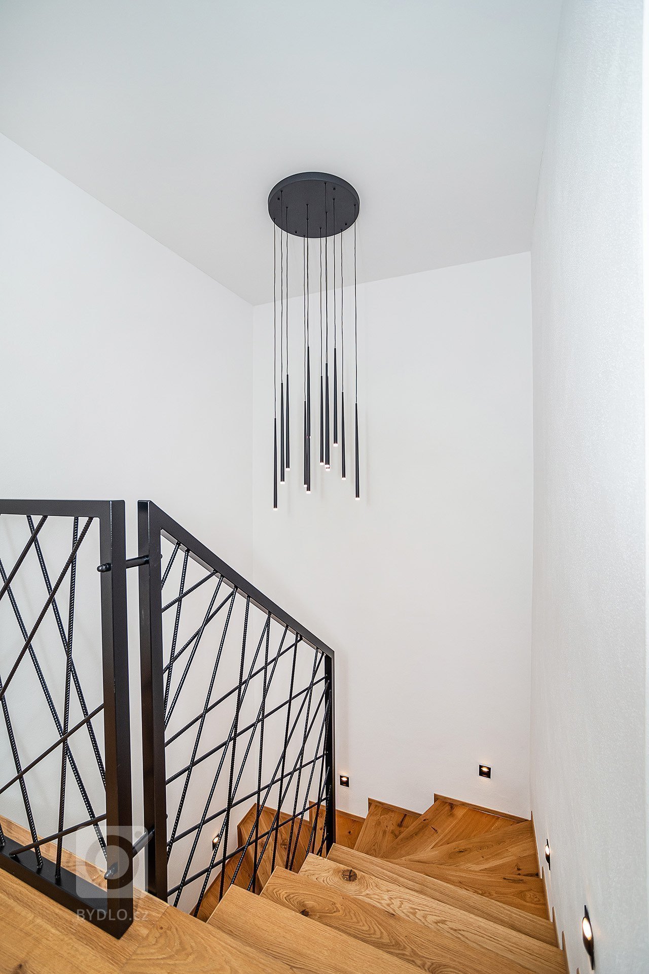 Interiér rodinného domu byl navržen v kombinaci olejovaného dubu, laminátu v odstínu taupe,&nbsp;černého lakovaného kovu a šedých odstínech velkoformátové…