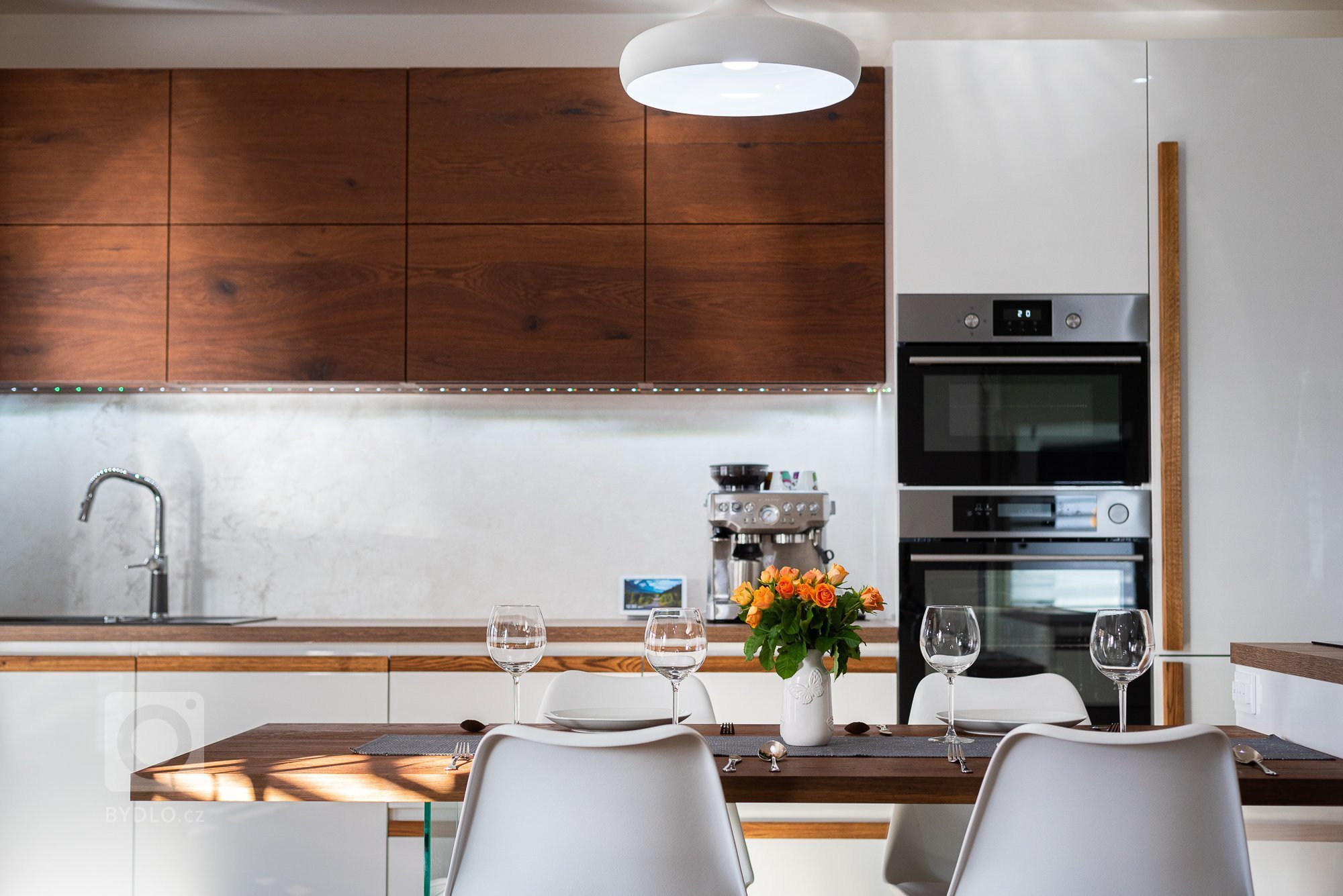 Jednoduchá a elegantní. Dominantou této kuchyňské linky je bezesporu dřevo v podobě drásané dýhy použité na horních skříňkách a jídelním stole, tak masivní…