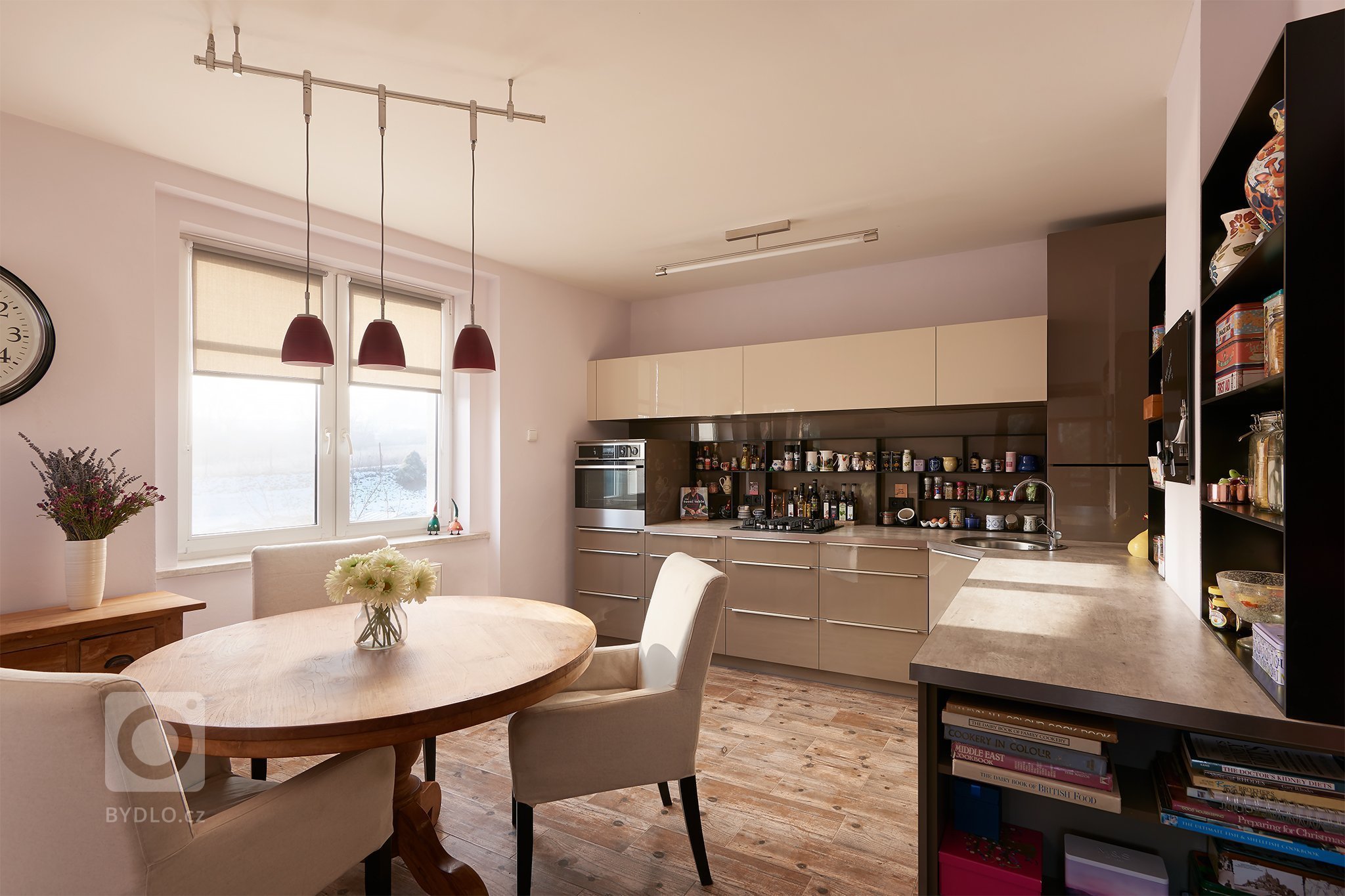 Kuchyňská sestava je realizována ve vysokolekslém laku v kávových odstínech s matnými černými doplňkami.