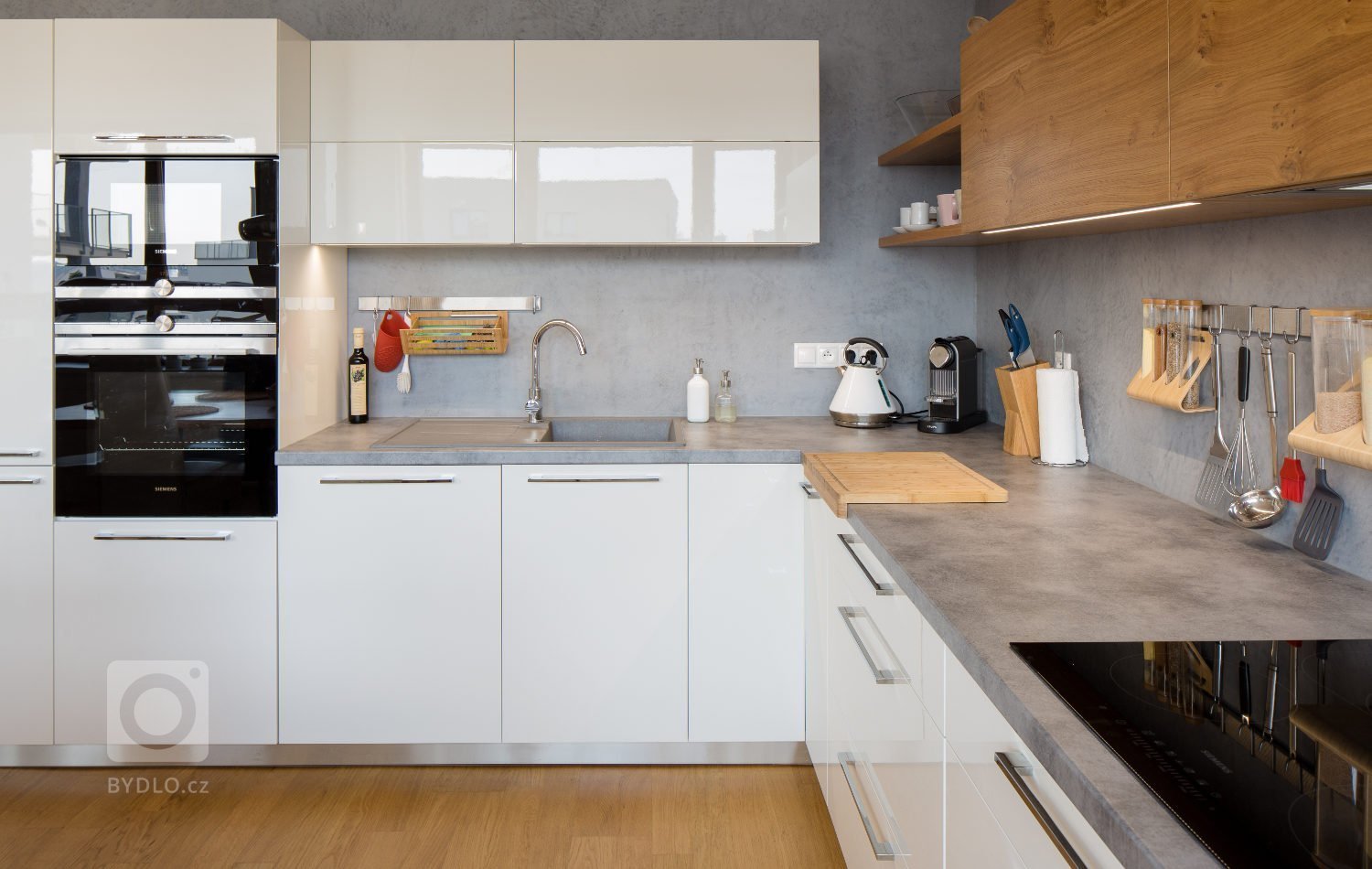 Představujeme prostornou&nbsp;sestavu do tvaru L. Nabídne vše pro pohodlnou práci v kuchyni. Chladný bílý lak příjemně doplňuje medový odstín dýhy, který…