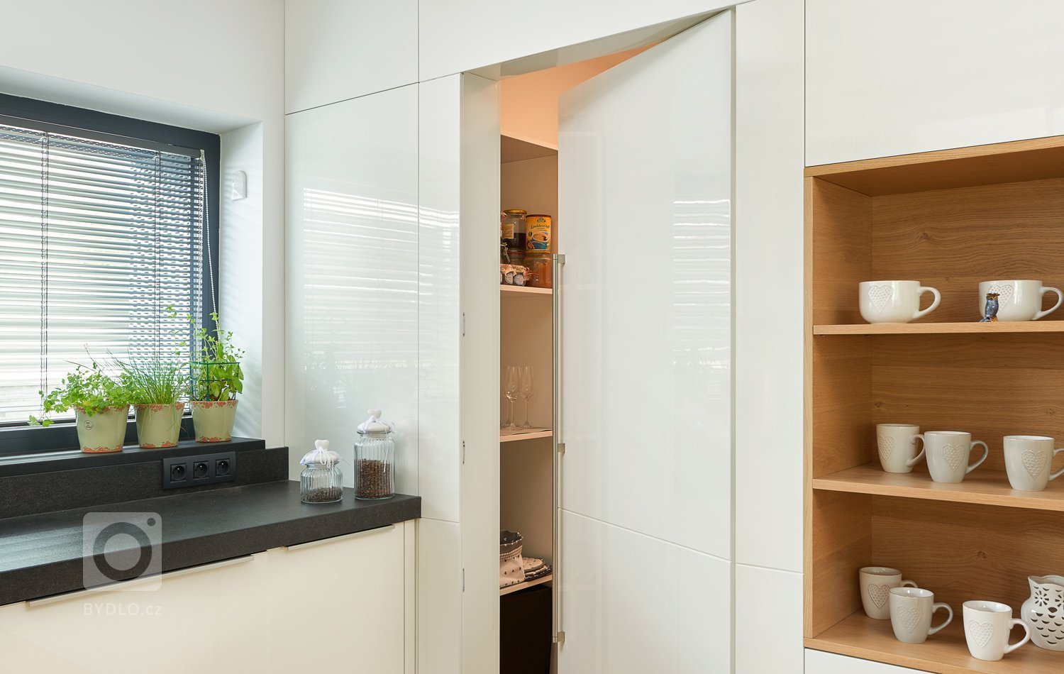 Interiér, kde se prolíná dýha dub rustikální přírodní spolu s bílým lakem ve vysokém lesku. Kuchyně získala v tomto prostorném domě místo při schodišti, které…