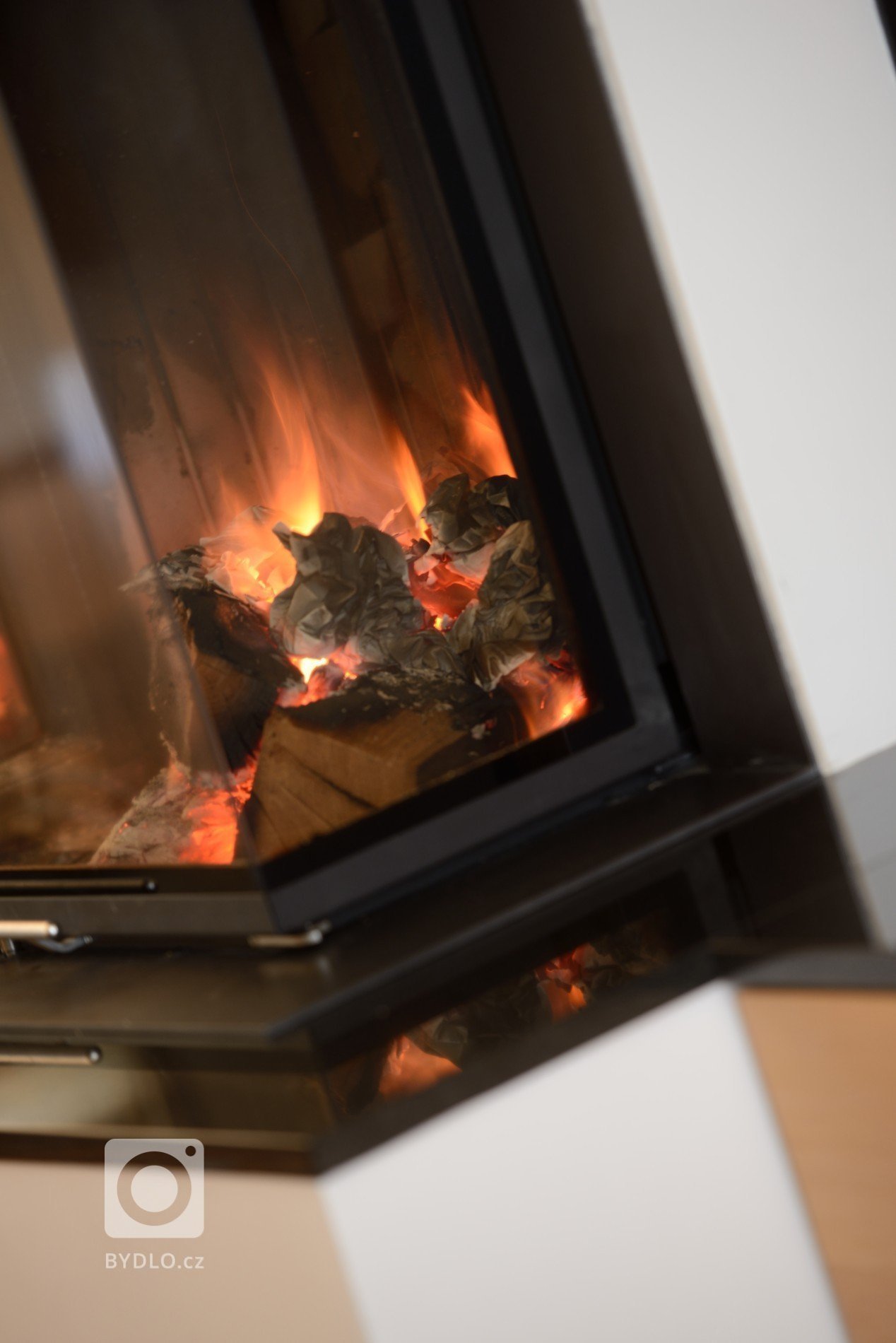 Třístranný krb s vestavěnou krbovou vložkou Brunner Panorama, žulovou spodní římsou a obestavbou z omítaného šamotu dělá radost v Praze - Kunraticích našemu…