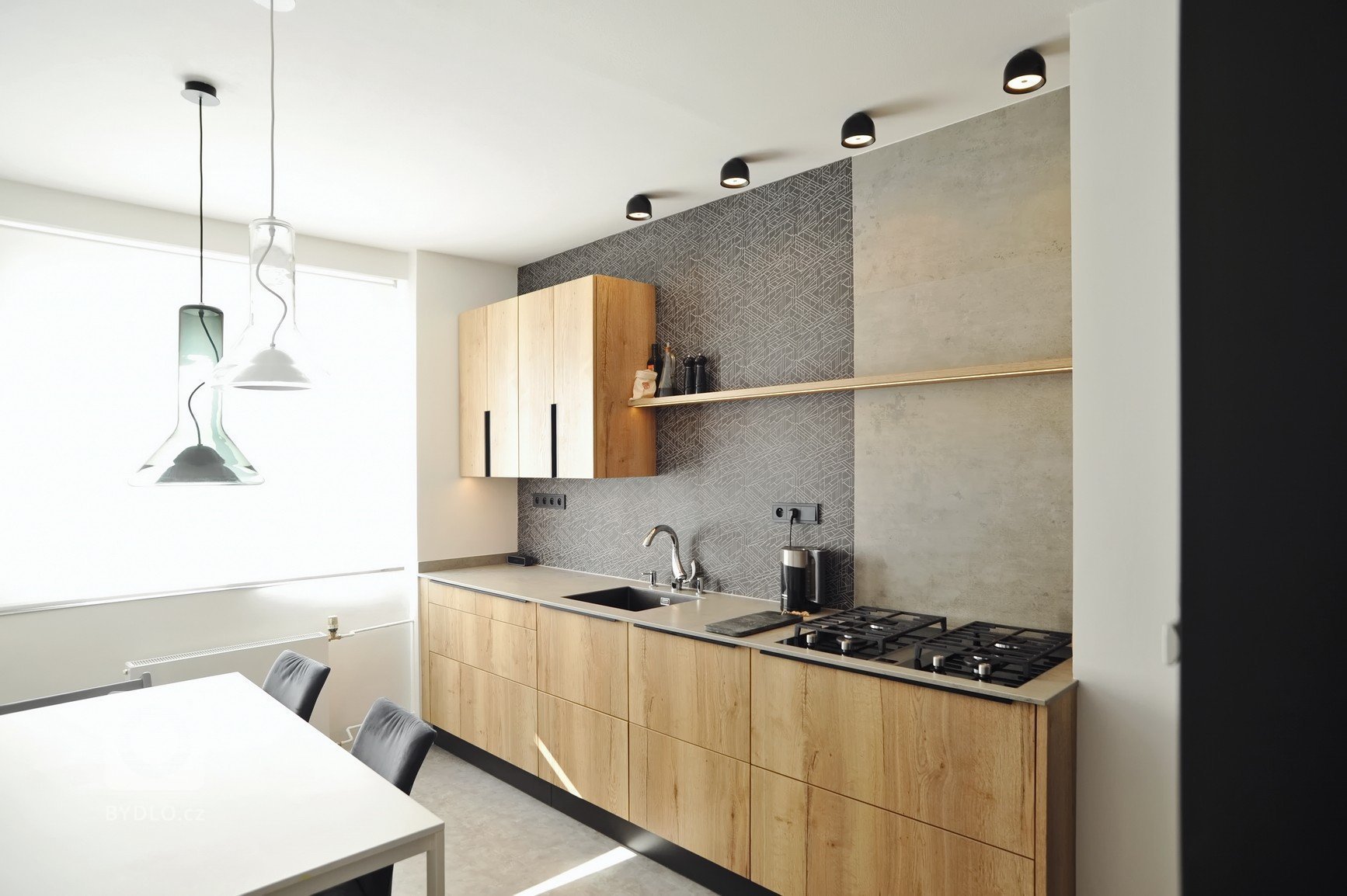 Realizace kuchyně ve skandinávském stylu. Schüller Cremona &ndash; imitace dub v kombinaci s matným sklem. Pracovní deska z keramiky, obklad z řezané mozaiky v…