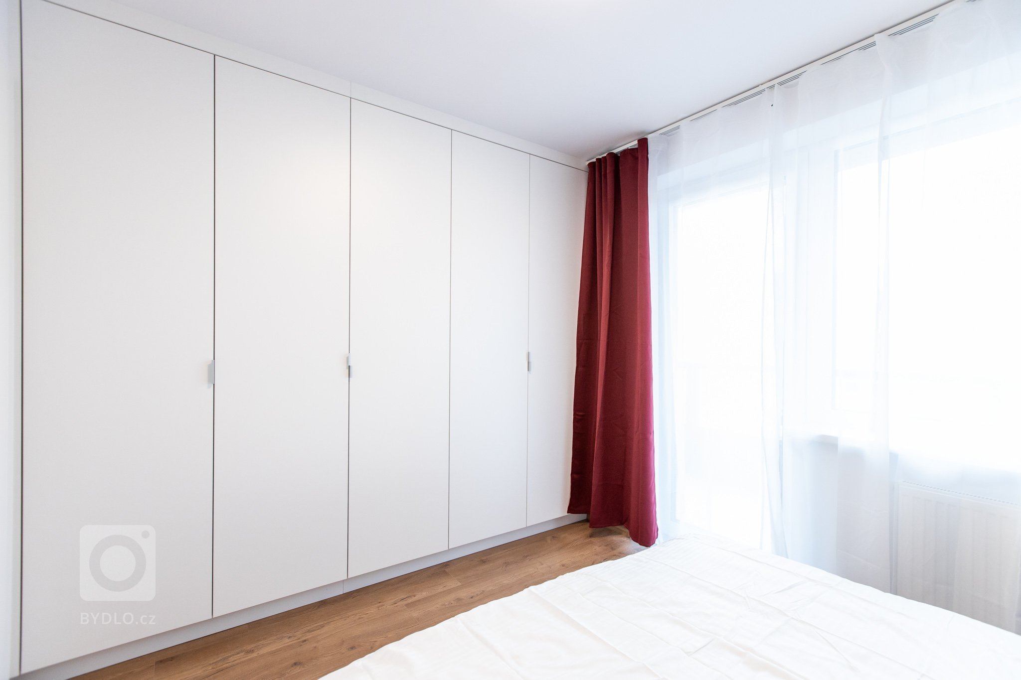 Krásna realizácia, ktorá dokonale prepája antracitovú kuchyňu s bielou obývacou zostavou.
