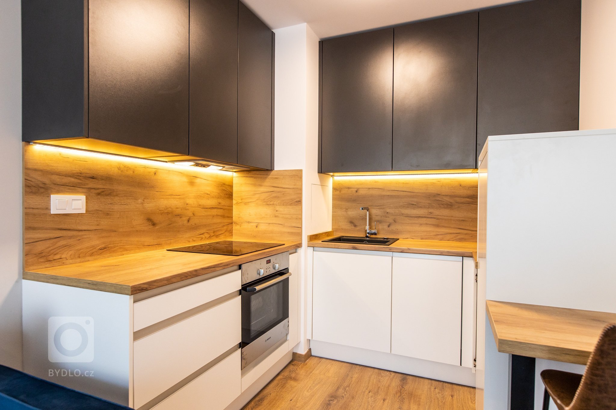 Krásne minimalisticky zariadený byt v Urban Residence, ktorého dominantou je modrá rohová sedačka. Kuchynská linka je krásne ladená v tónoch ceého bytu, aby…