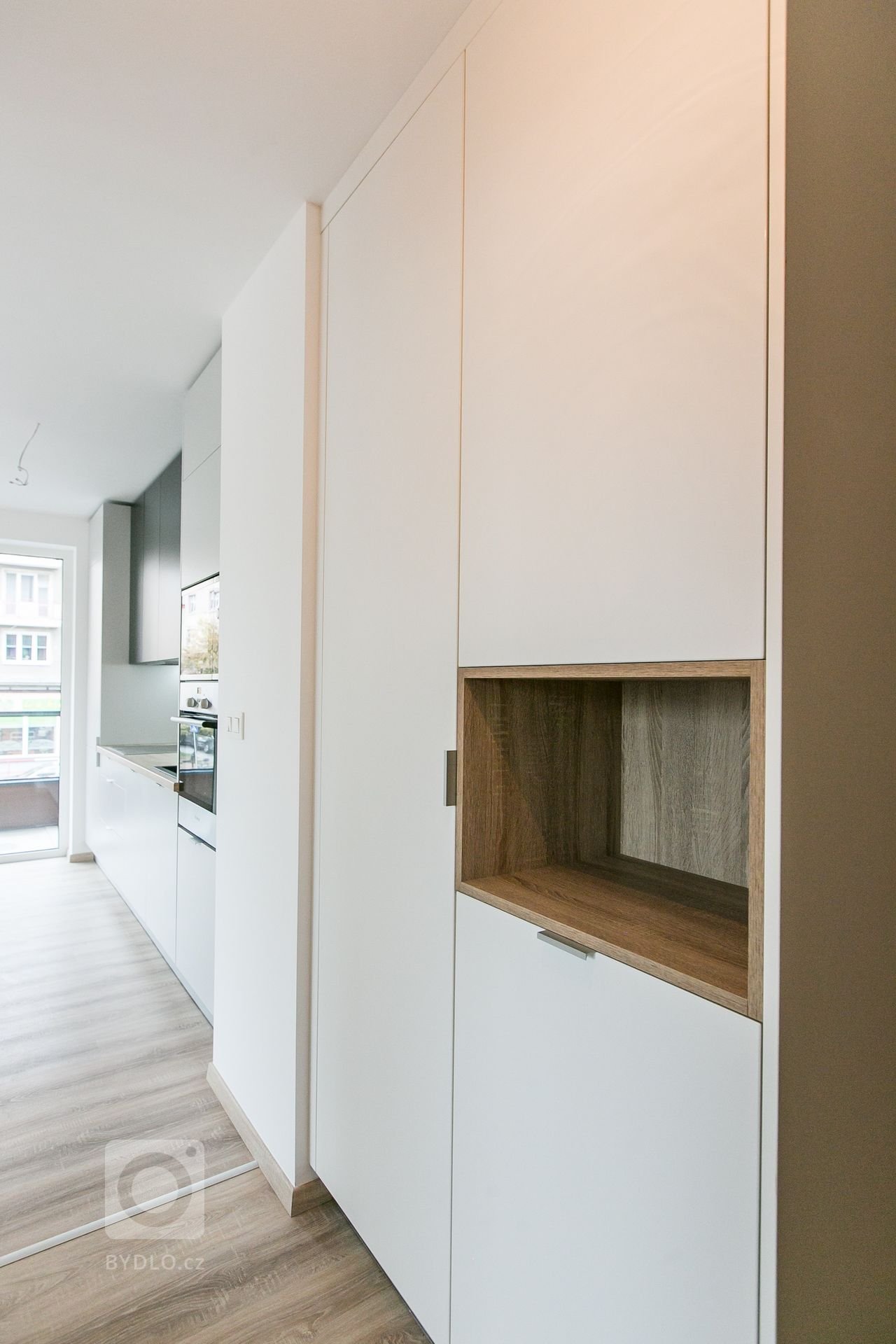 Použité materiály:

Horné skrinky: antracitový mat
Dolné a vysoké skrinky:&nbsp;biely perleťový mat
Vstavané skrine: biely perleťový mat
Výklenok: dub…