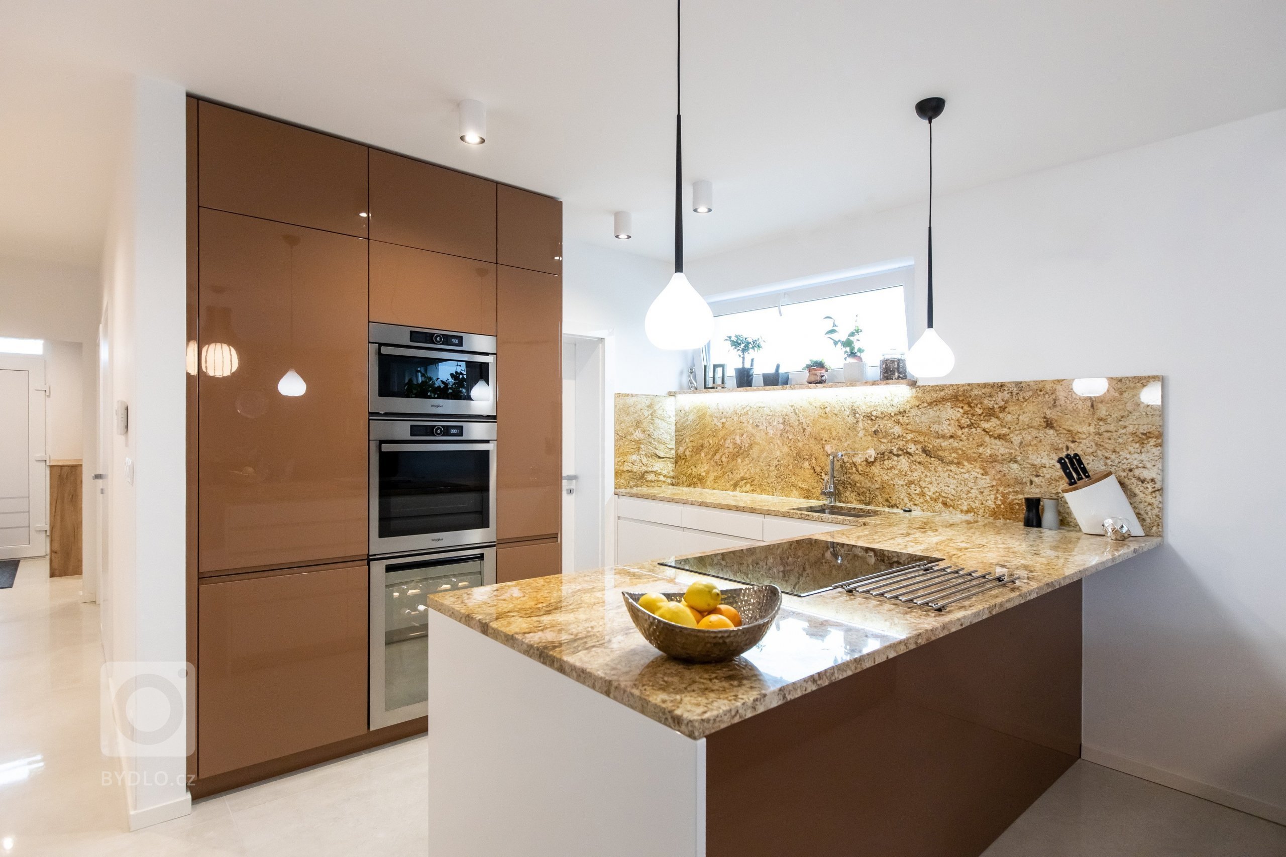 Kombinácia predstáv klienta a skúsenosti dizajnéra vytvorili jedinečný originál kuchyne z materiálov vo vysokom lesku. K dominantnej škoricovej farbe horných…