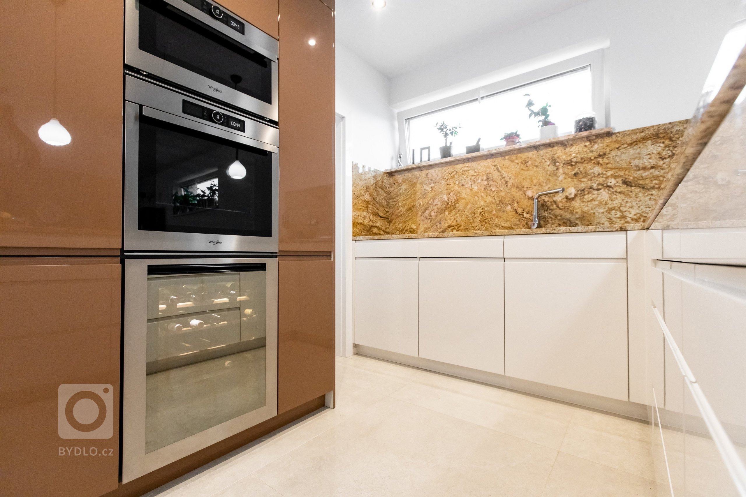 Kombinácia predstáv klienta a skúsenosti dizajnéra vytvorili jedinečný originál kuchyne z materiálov vo vysokom lesku. K dominantnej škoricovej farbe horných…