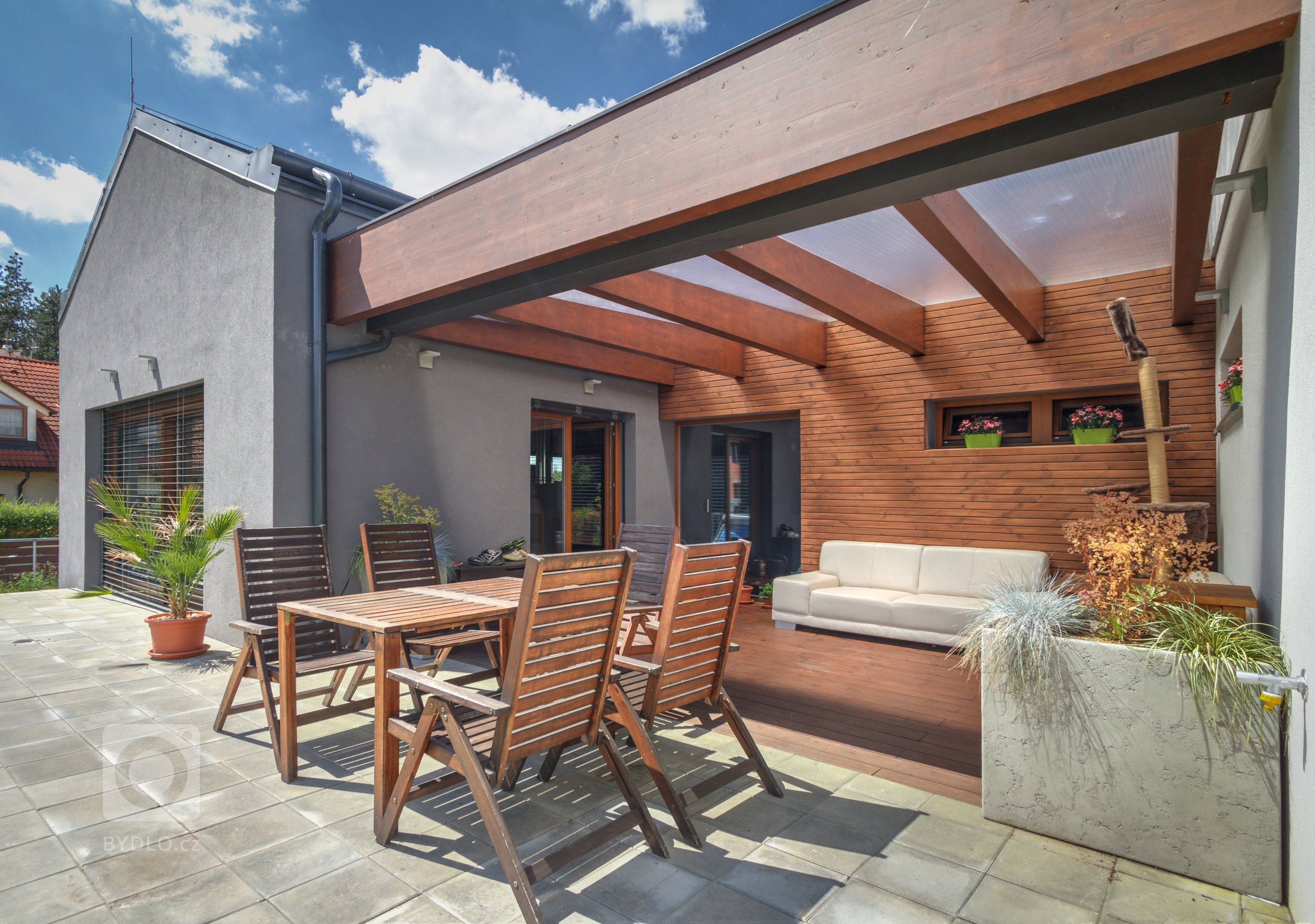 Dům je umístěn v severní části pozemku a otevírá se velkým francouzským oknem a atriem na jih do zahrady. Svou formou - tvarem střech a velikostí hmot -…