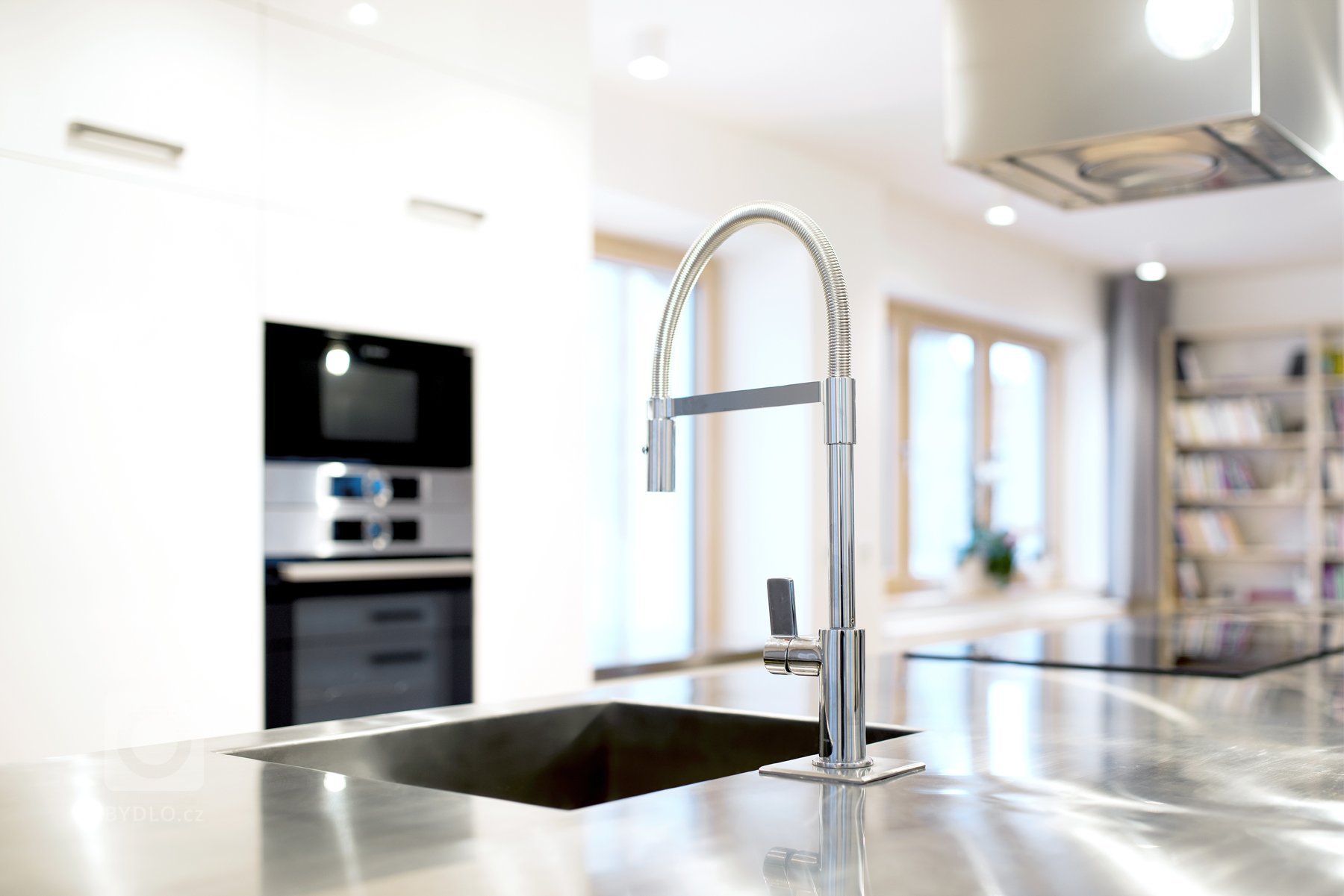 Sofistikovaný moderní vzhled kuchyně hraje hlavní roli v&nbsp;obytném prostoru zrekonstruovaného podkrovního bytu. Kuchyně je se zbytkem pokoje, který slouží…