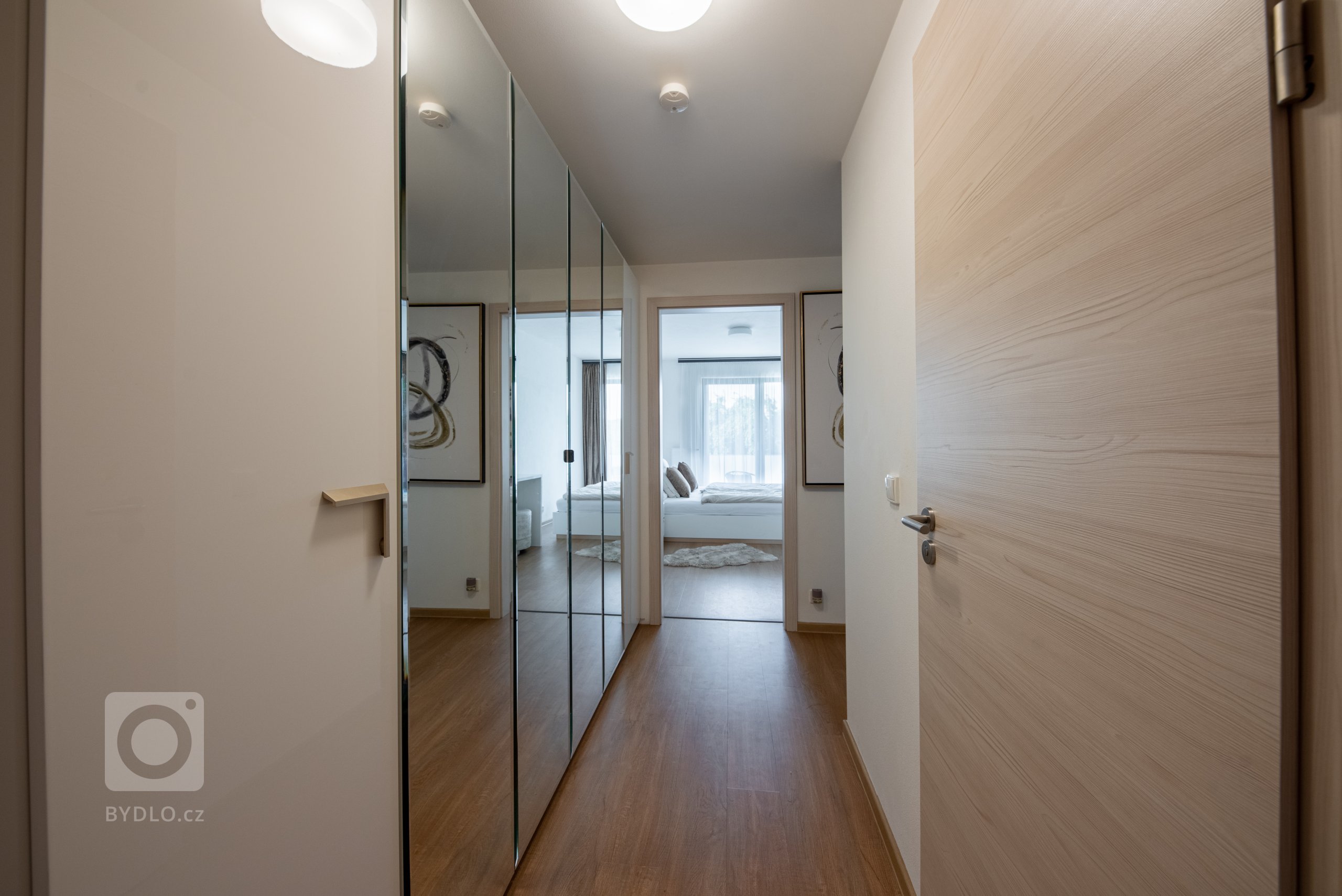 Realizace moderního obývacího pokoje a ložnice v glamour stylu.&nbsp;

Sedací souprava je z kolekce MONO s výsuvnými sedáky, obývací stěna je v černém matném…