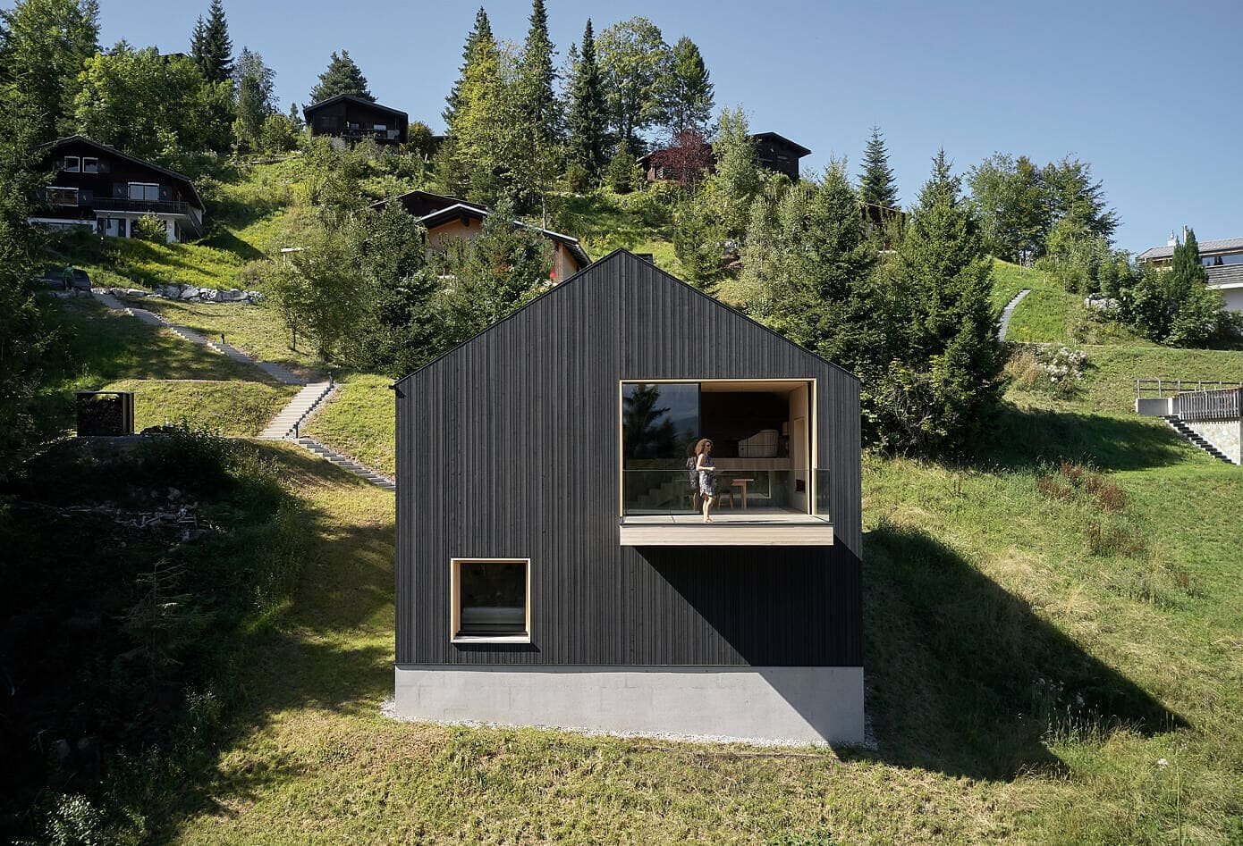 Černě oděný víkendový dům u lesa