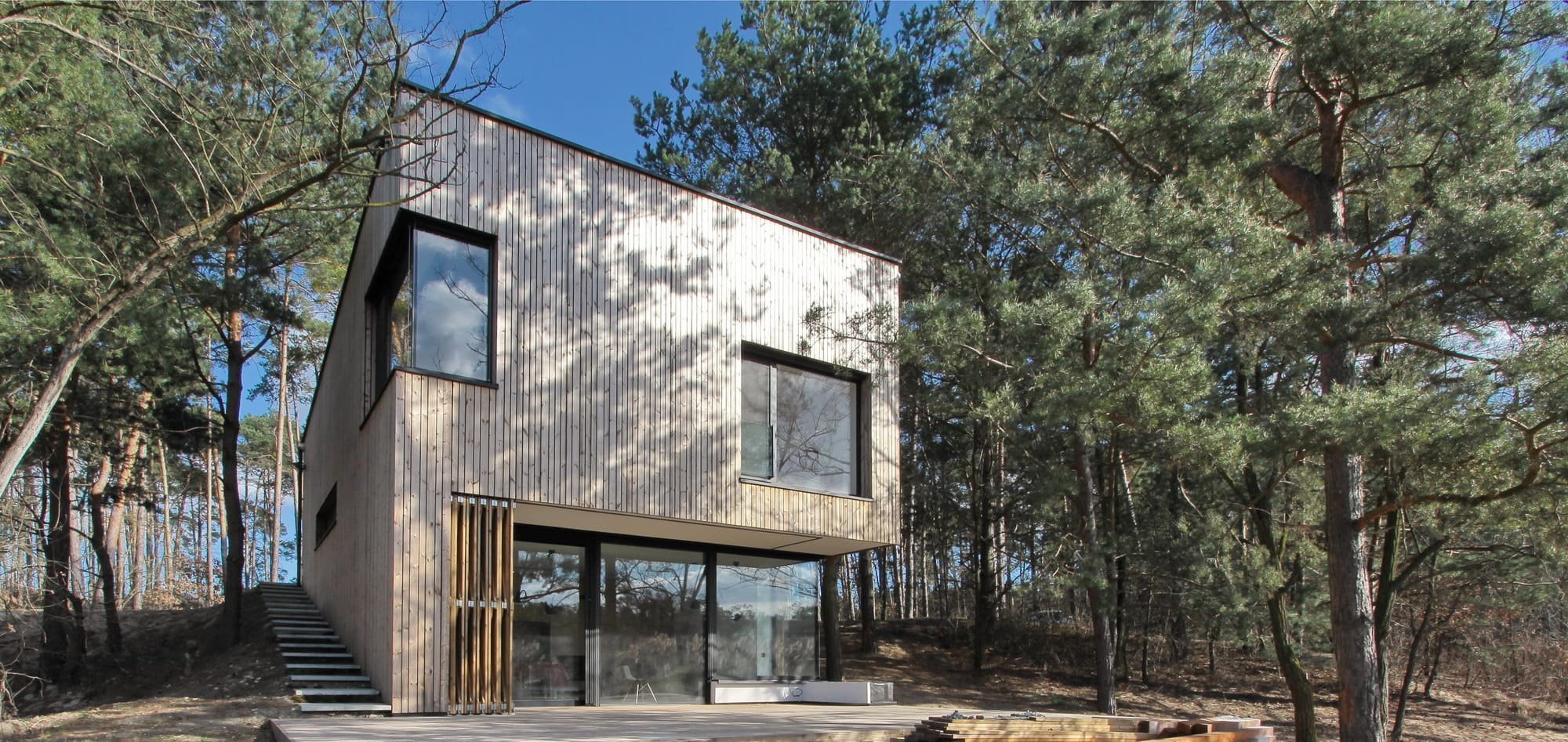 Chata v borovicovém lese na břehu jezera