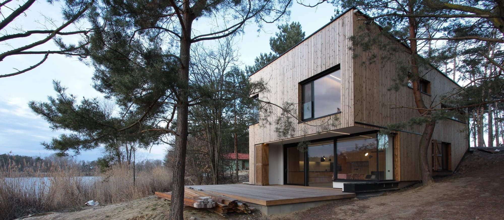 Chata v borovicovém lese na břehu jezera