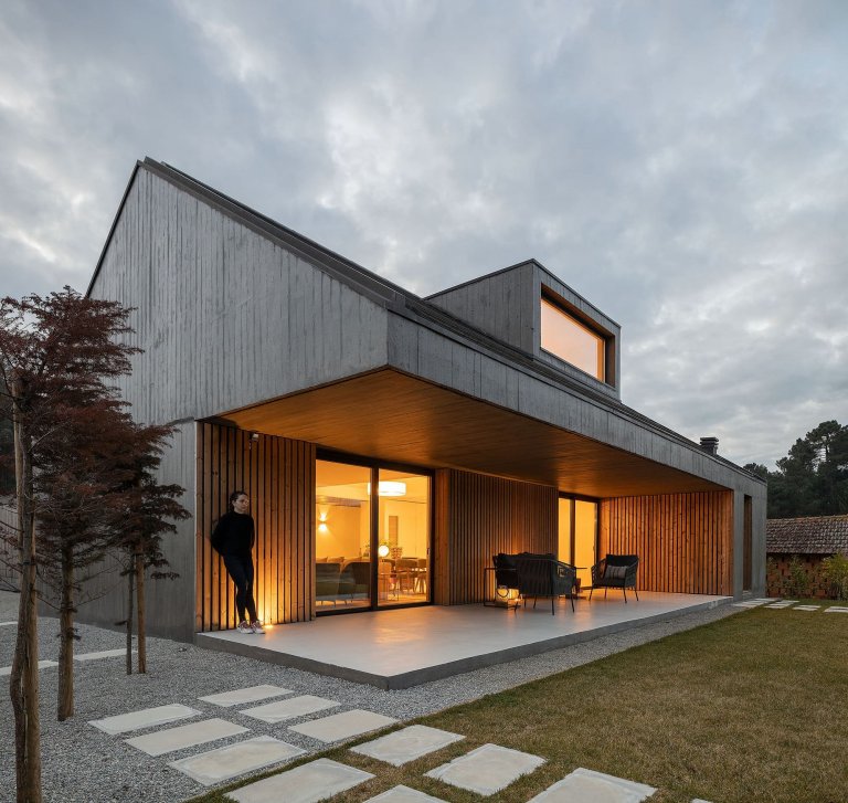 Dům s dřevěnou fasádou a geometrickými světlíky