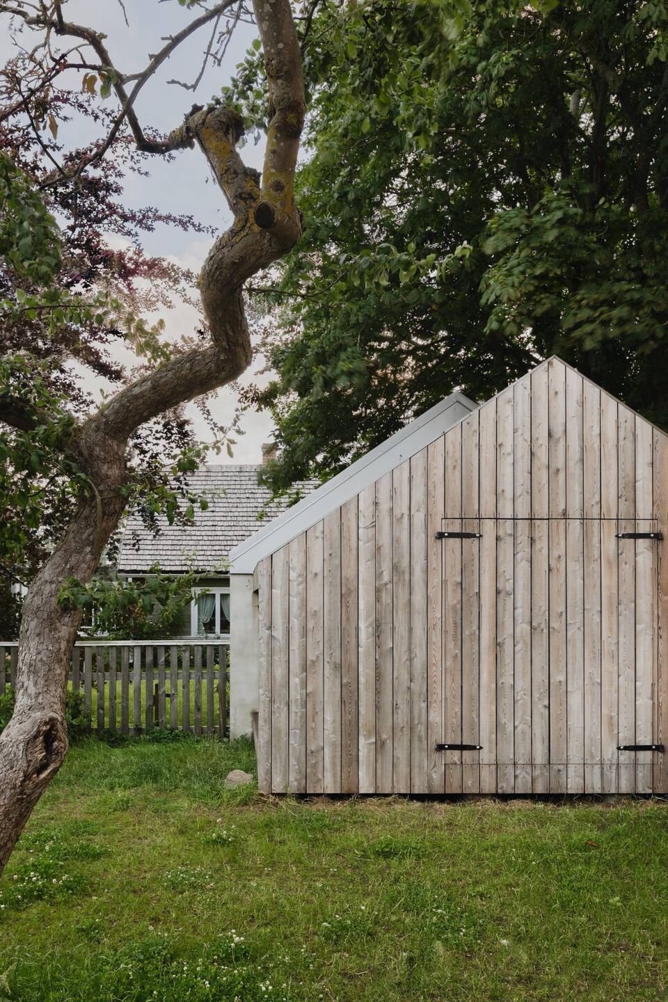 Malý dřevěný dům vsazený do zahrady