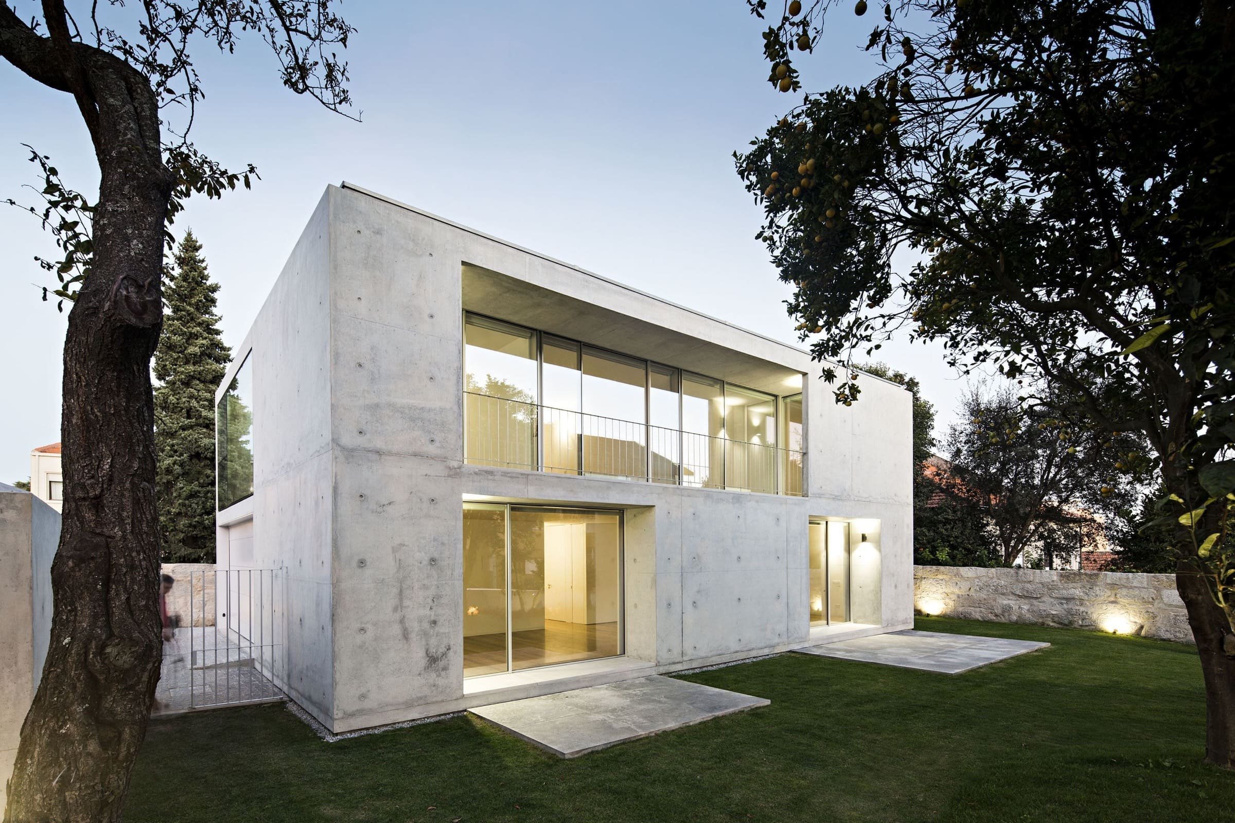 Monolitický betonový kvádr narušují pouze velké prosklené otvory, které propojují obytnou část domu se zahradou