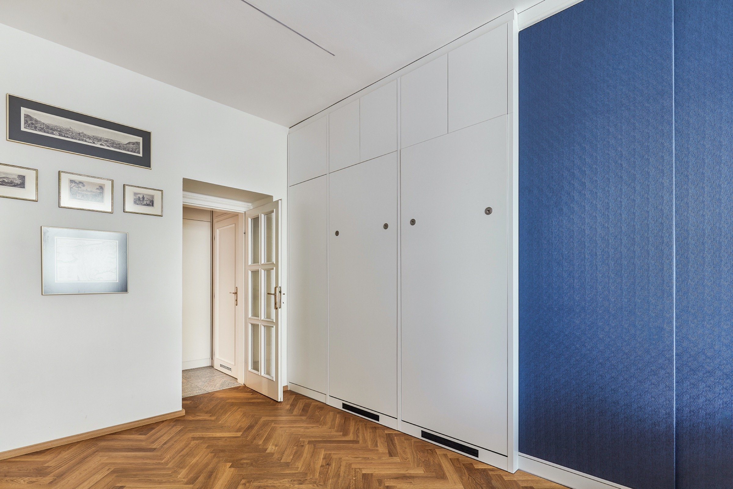 Rekonstrukce bytu s modrou kuchyní a knihovnou