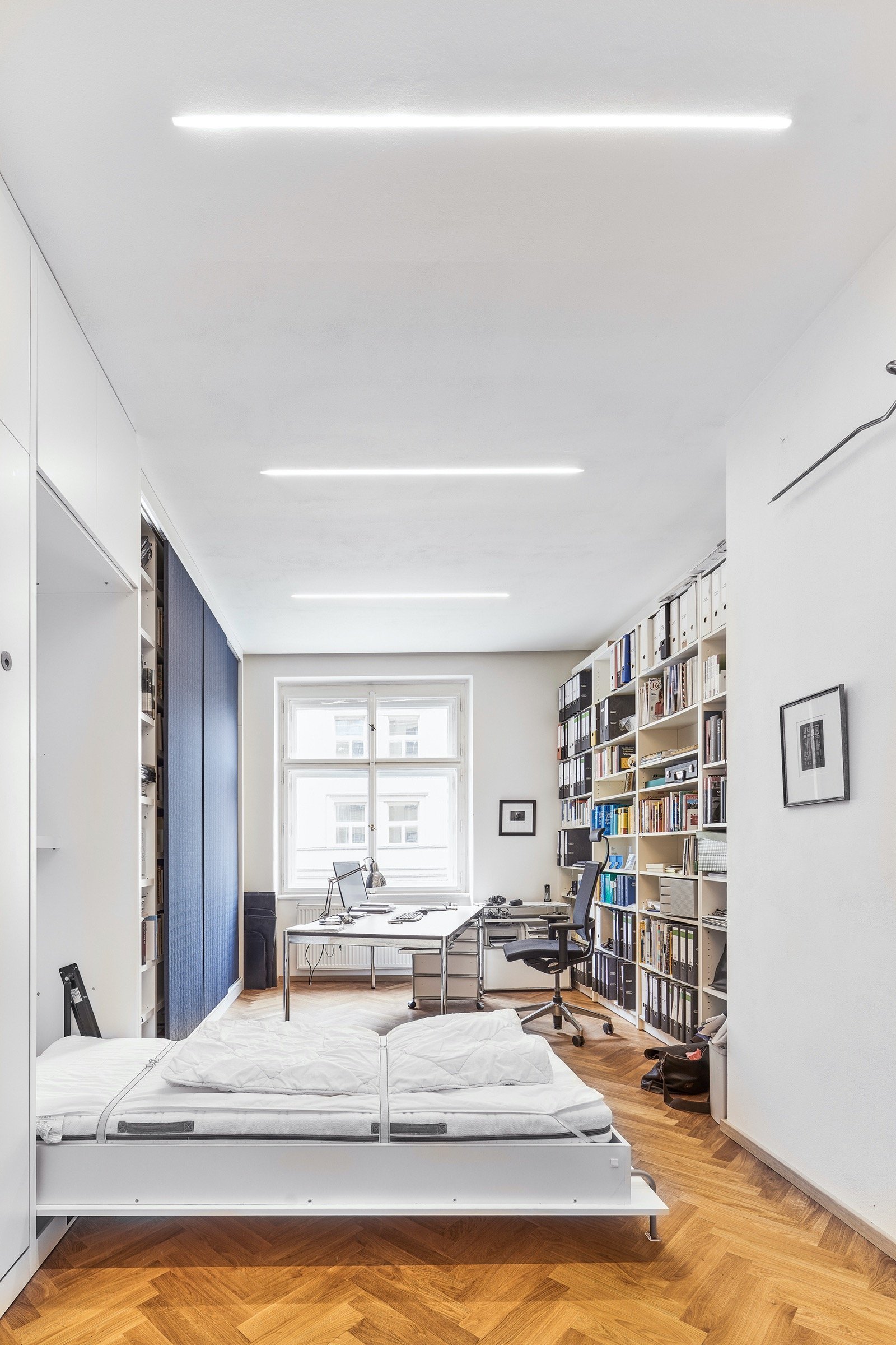 Rekonstrukce bytu s modrou kuchyní a knihovnou