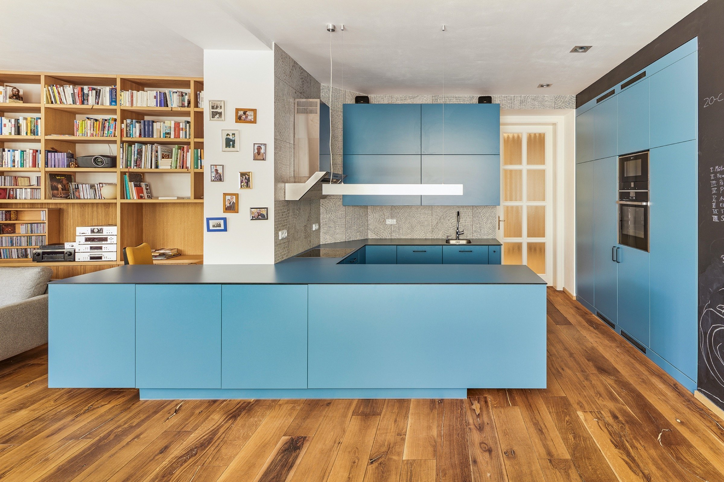 Rekonstrukce bytu s modrou kuchyní a knihovnou