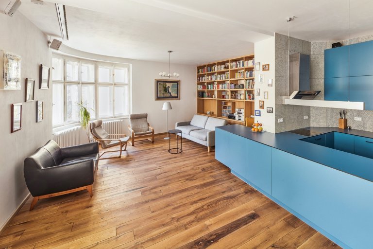 Rekonstrukce bytu s modrou kuchyní a knihovnou