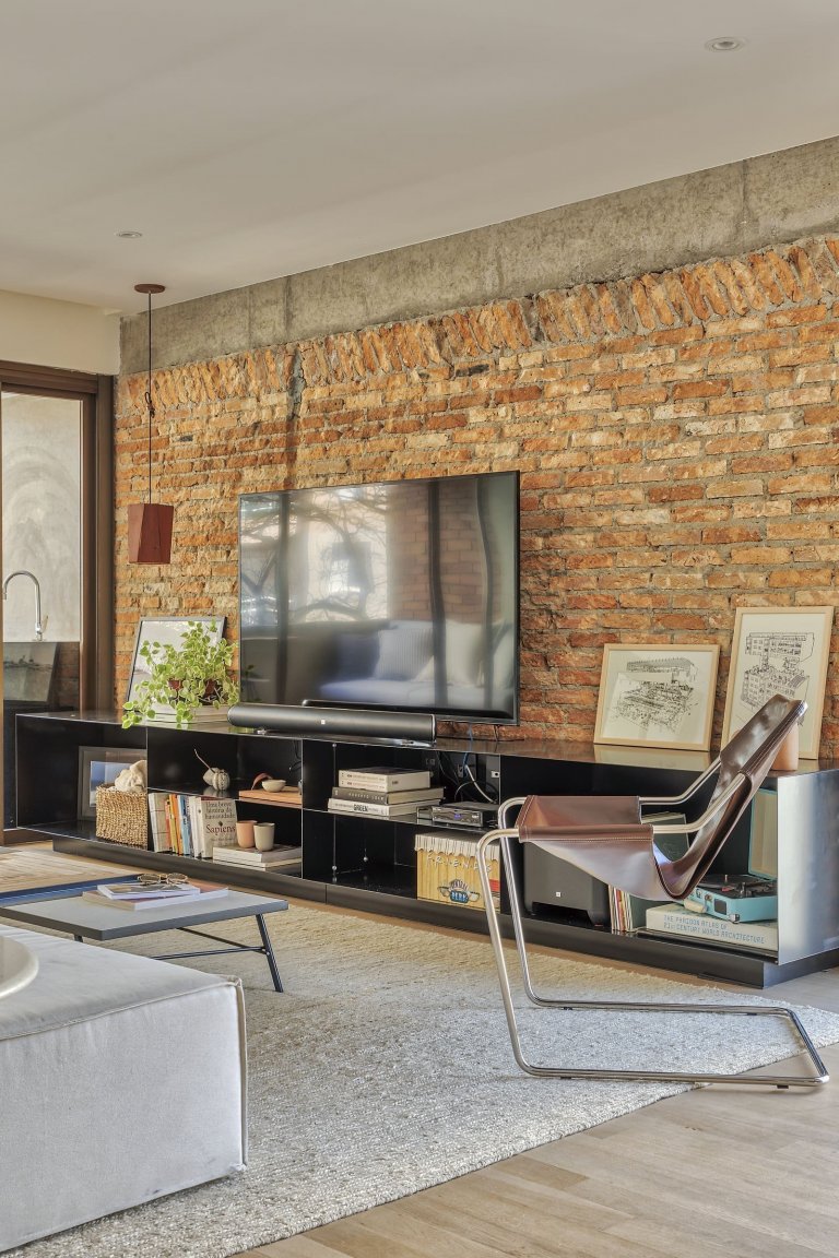 Cihlová stěna prostor příjemně oživuje.