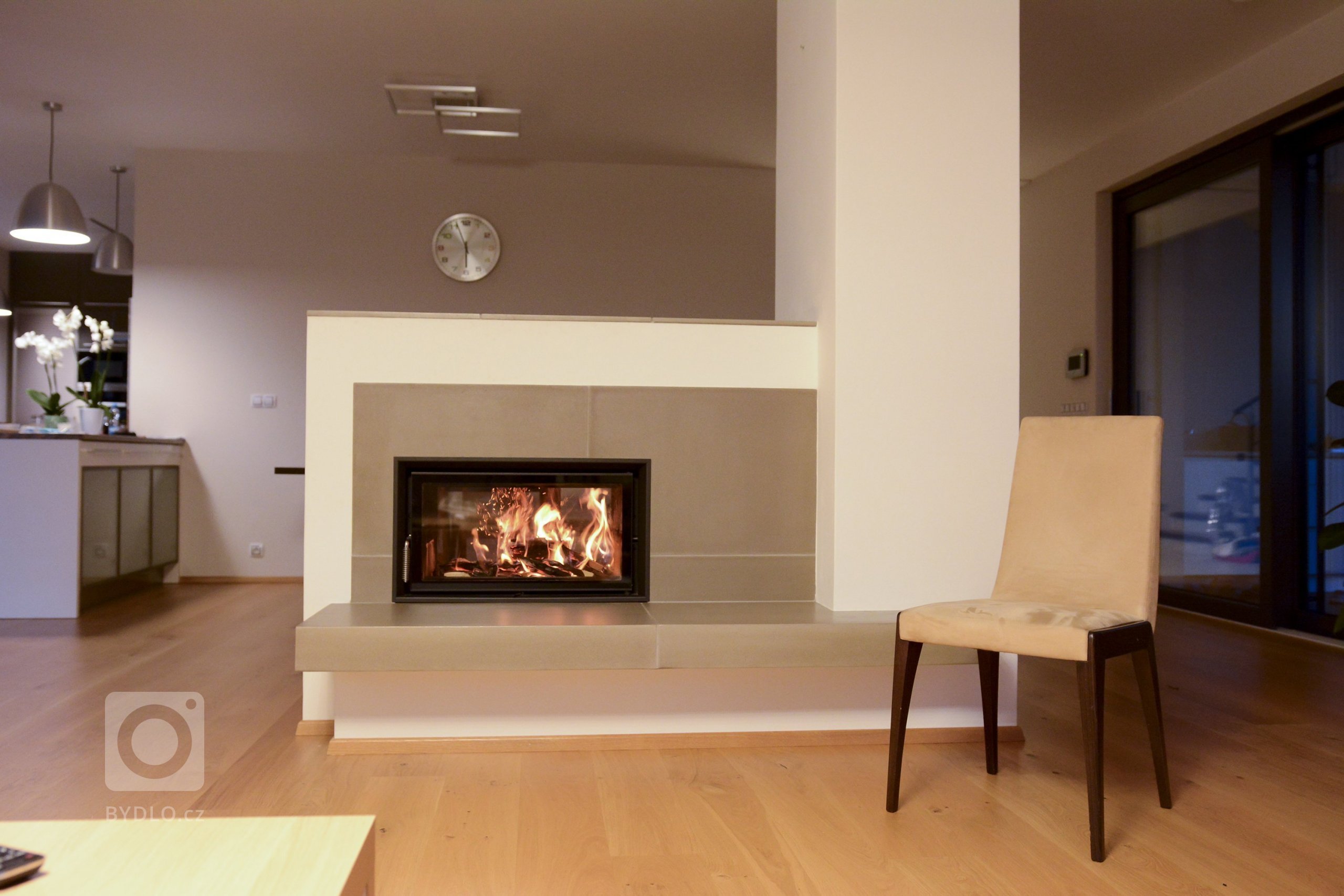 Obestavba kamnové vložky HKD 7 od firmy Brunner s tahovým systémem MSS. Krb opticky odděluje jídelní&nbsp; a obývákovou část domu. Tahový systém slouží k…
