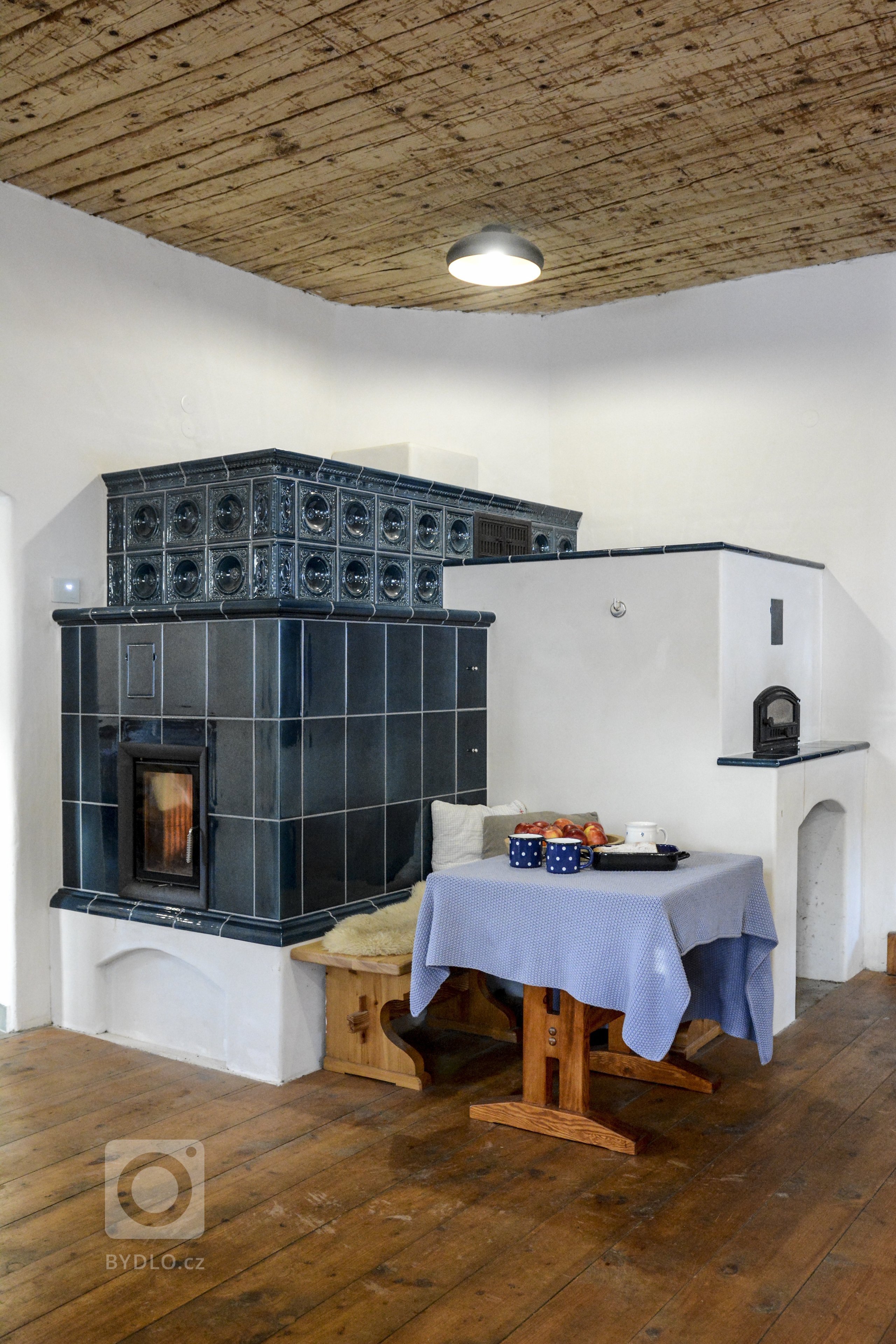 Realizace Romana Hanuše. Kachlová kamna s píckou poháněná vložkou Brunner HKD 4.1. Použity byly kachle hladké a Rustikal a&nbsp;římsa Flora, vše v tmavě modré…