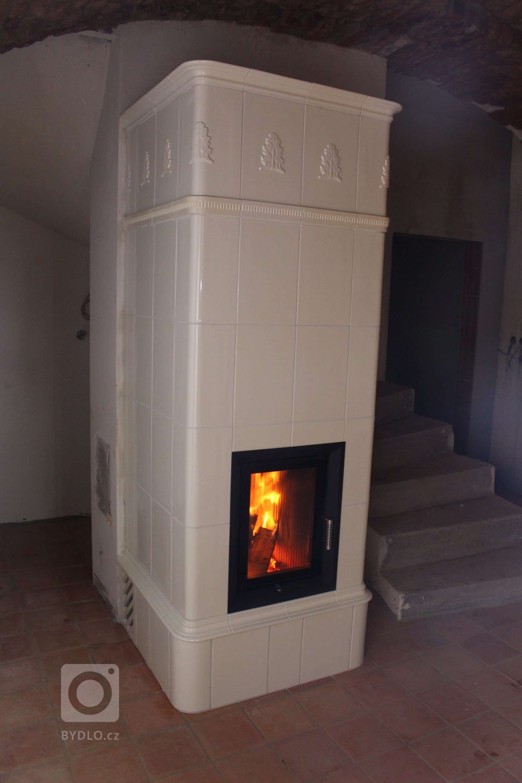 Motiv Lenner na realizaci sloupových kamen z jidřichohradeckého Kamnářství K-3. Kachle K&amp;K POKER Kamnářství Bechyně, římsa viola.
