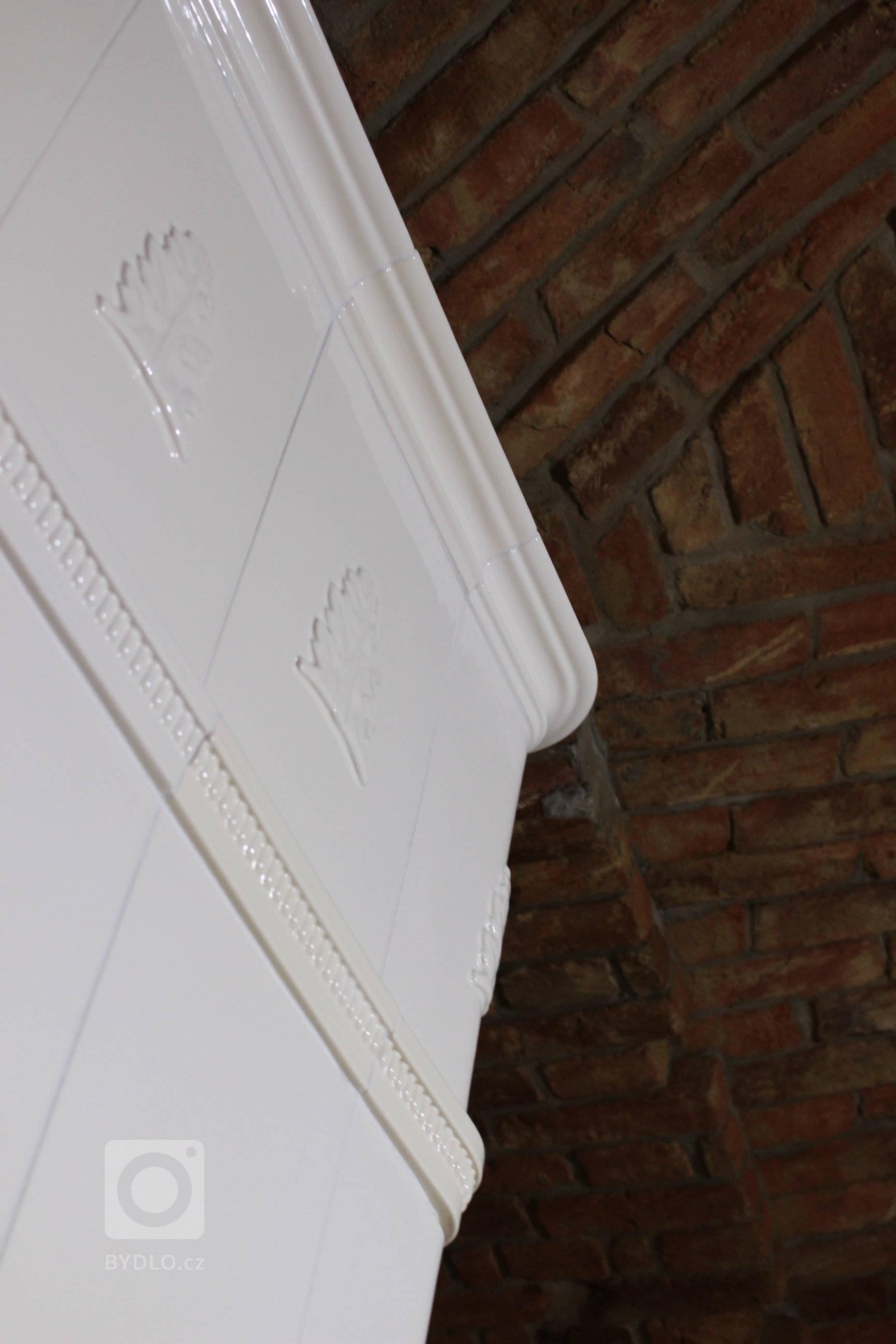 Motiv Lenner na realizaci sloupových kamen z jidřichohradeckého Kamnářství K-3. Kachle K&amp;K POKER Kamnářství Bechyně, římsa viola.
