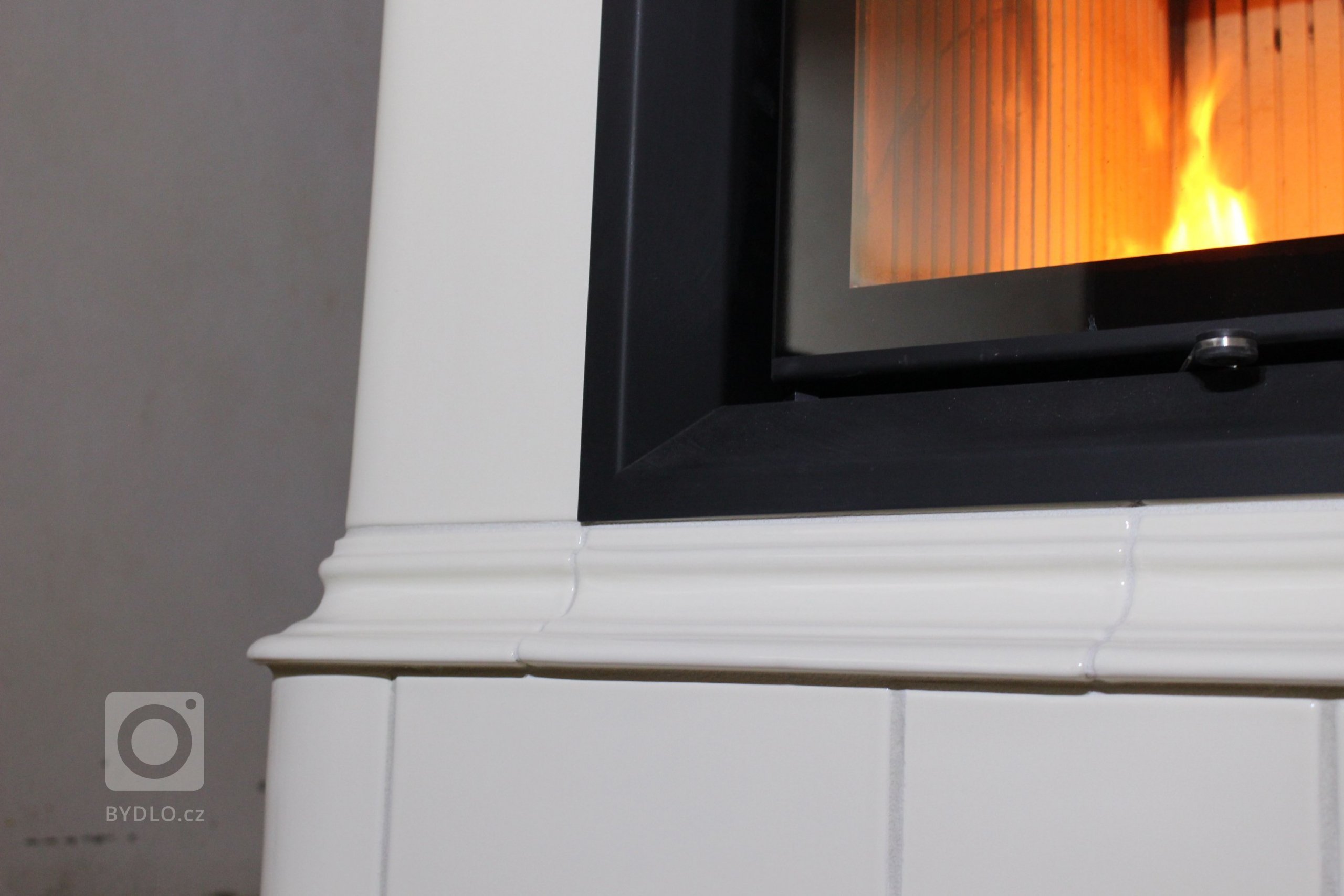 Motiv Lenner na realizaci sloupových kamen z jidřichohradeckého Kamnářství K-3. Kachle K&amp;K POKER Kamnářství Bechyně, římsa viola.
