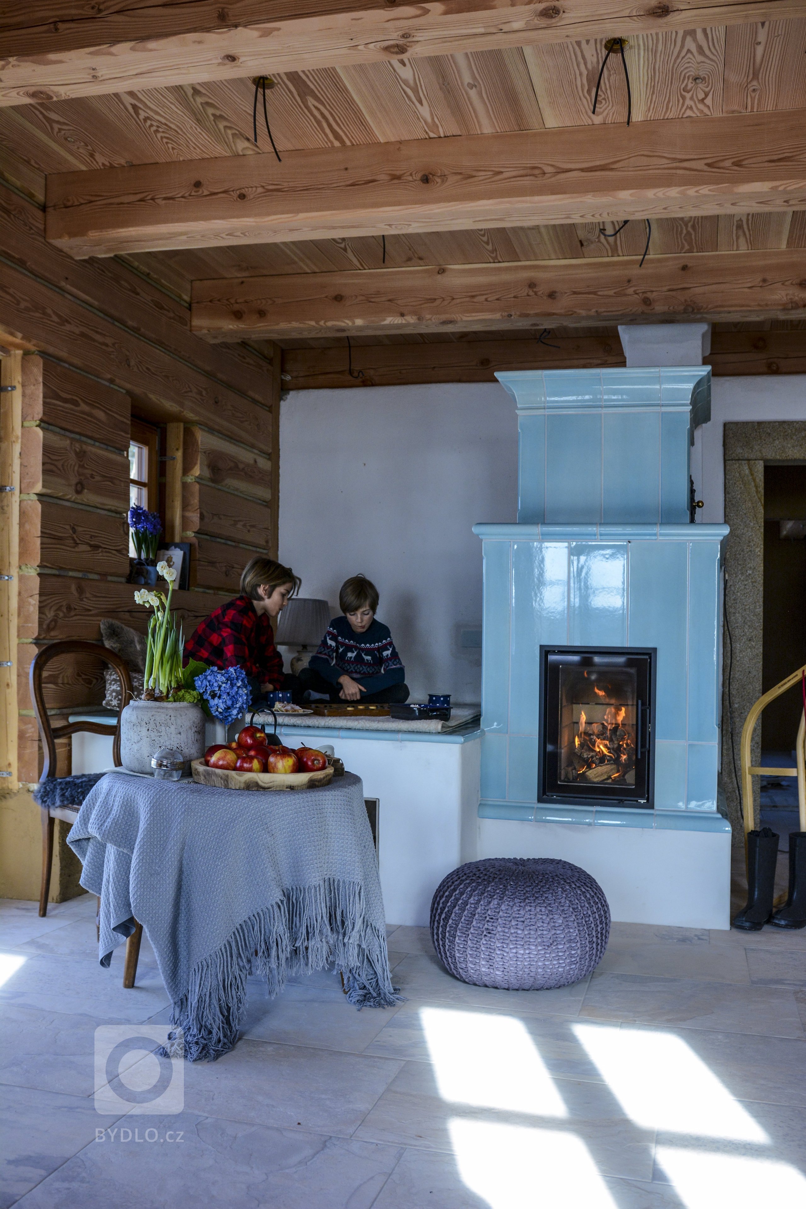 Jemně modrá&nbsp;kamna s ležením. Realizace Roman Hanuš. Keramika K&amp;K POKER, Kamnářství Bechyně. Kachle typu Robust.
