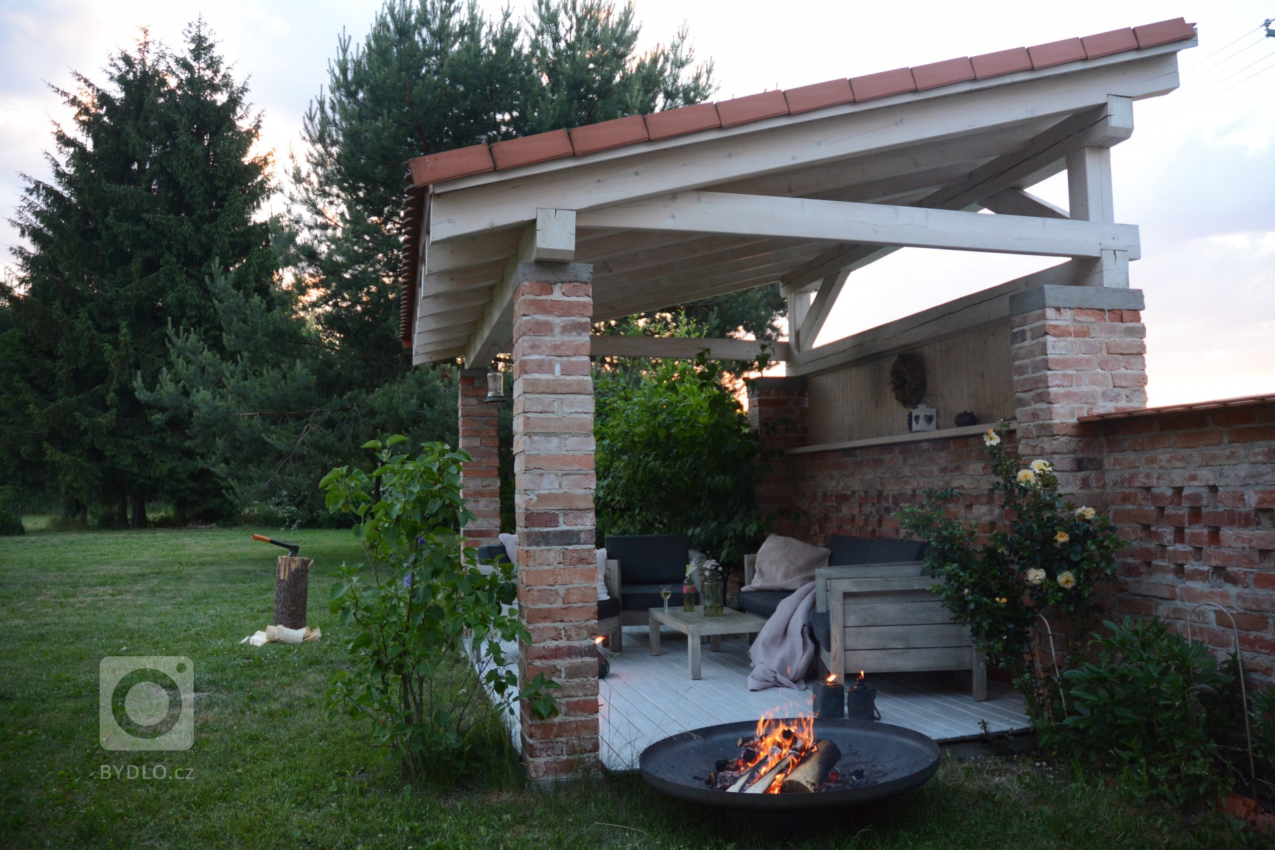 Venkovní altán ze starých pálených cihen v kombinaci s přírodním dřevem v bílé lazuře.