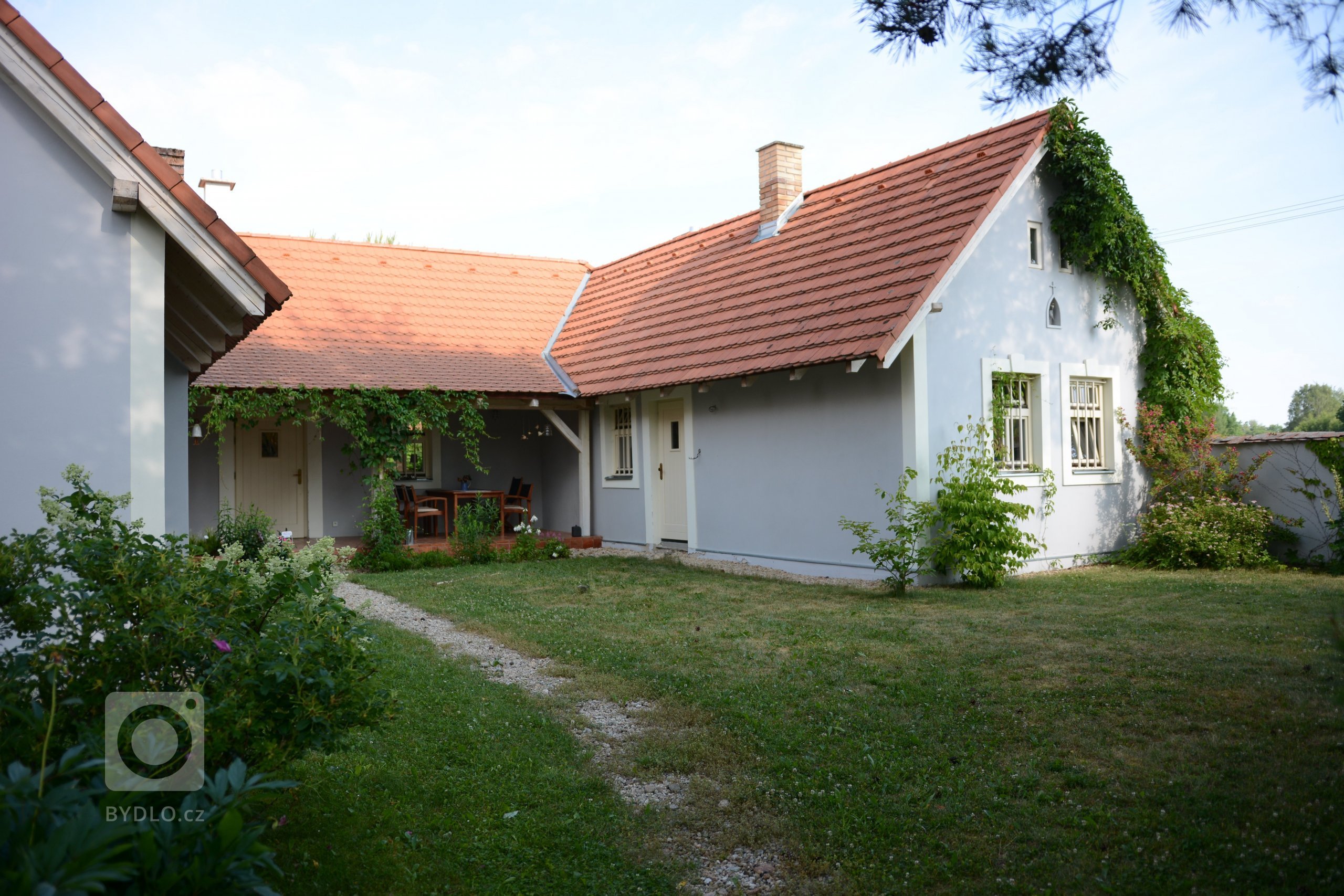 Klasické jihočeské stavení ve tvaru U s šedo-bílou omítkou a klasickými okny. Střechu tvoří tradiční pálená krytina „bobrovka“.